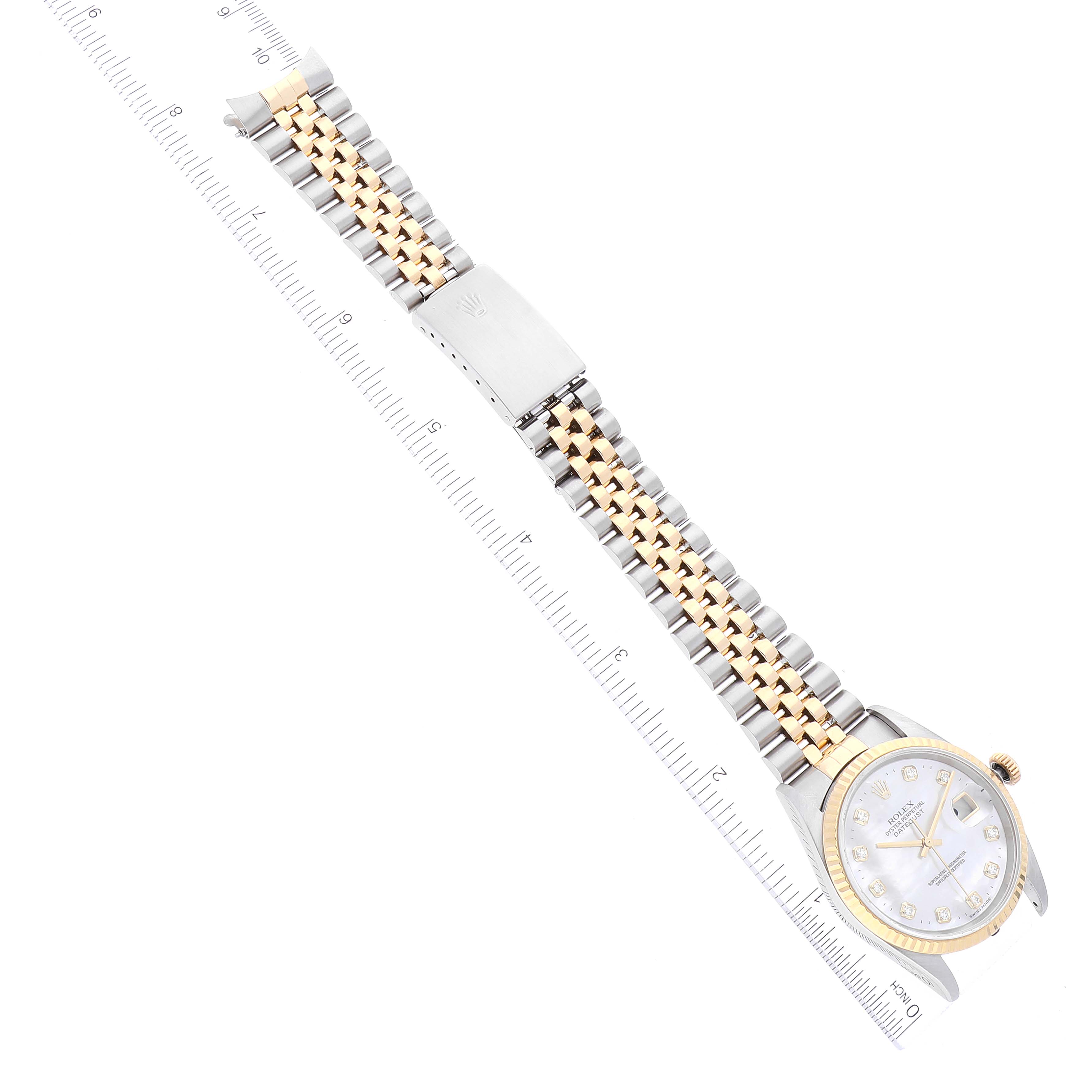 The image shows the Rolex Datejust 16233 Men's Steel and Gold (two tone) Mother of Pearl Dial 16233 Men's Steel and Gold (two tone) Mother of Pearl Dial watch positioned flat with a full view of its dial, bracelet, and clasp, accompanied by a measurement ruler.