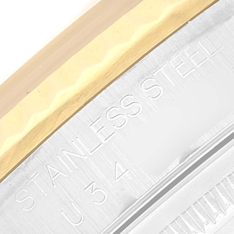 This image shows a close-up of the bezel and part of the case back of a Rolex Datejust 16233 Men's Steel and Gold (two tone) Mother of Pearl Dial 16233 Men's Steel and Gold (two tone) Mother of Pearl Dial watch engraved with "STAINLESS STEEL."