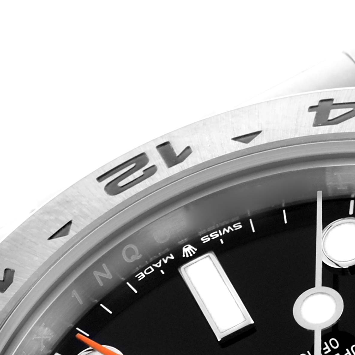 The image shows a close-up of the Rolex Explorer M226570-0002 Men's Stainless Steel Black Dial M226570-0002 Men's Stainless Steel Black Dial's bezel, dial, and markers from an angled perspective.