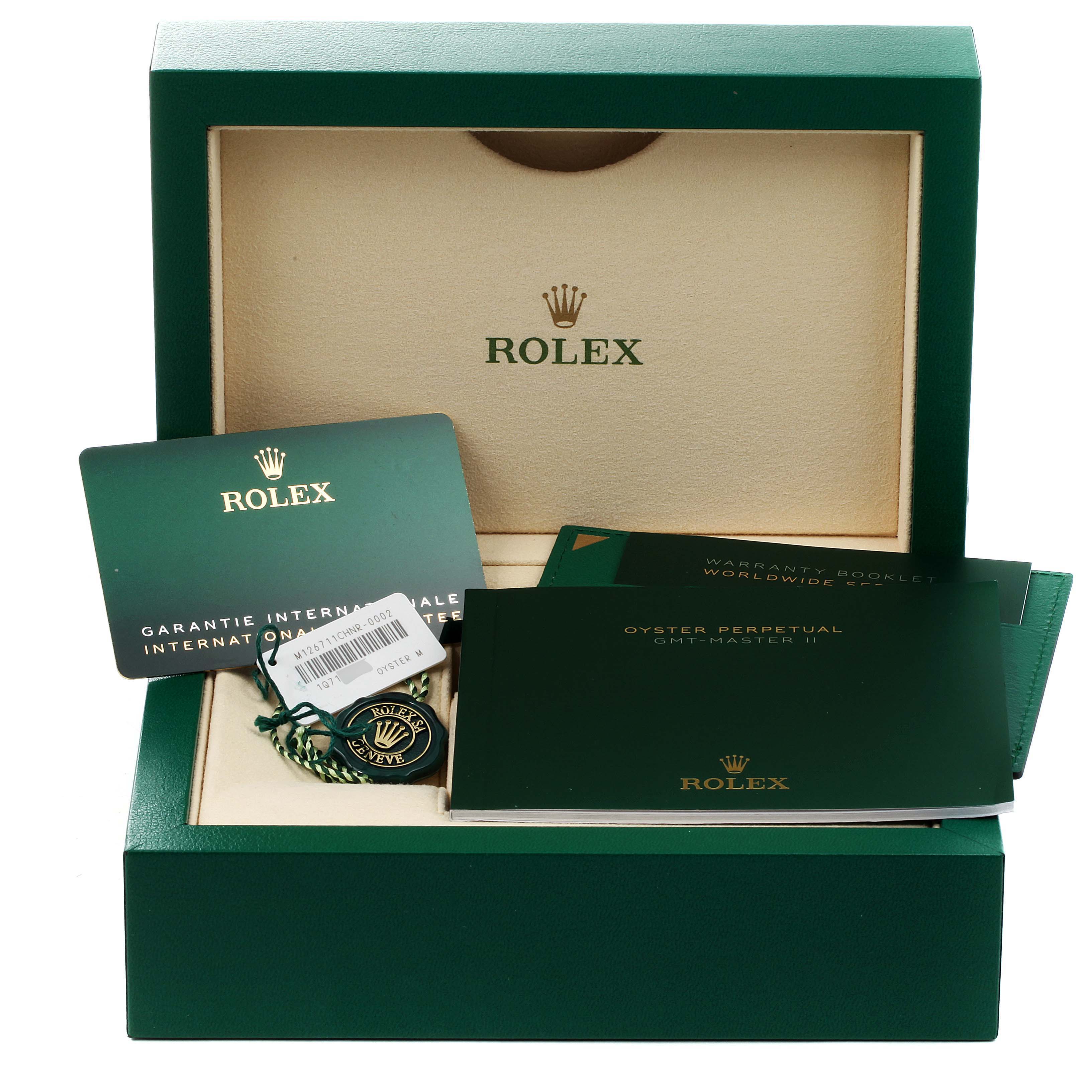 The image shows the packaging, warranty cards, and booklets for the Rolex GMT-Master 126711 Men
s Rose Gold Black Dial 126711 Men
s Rose Gold Black Dial model from a front angle.