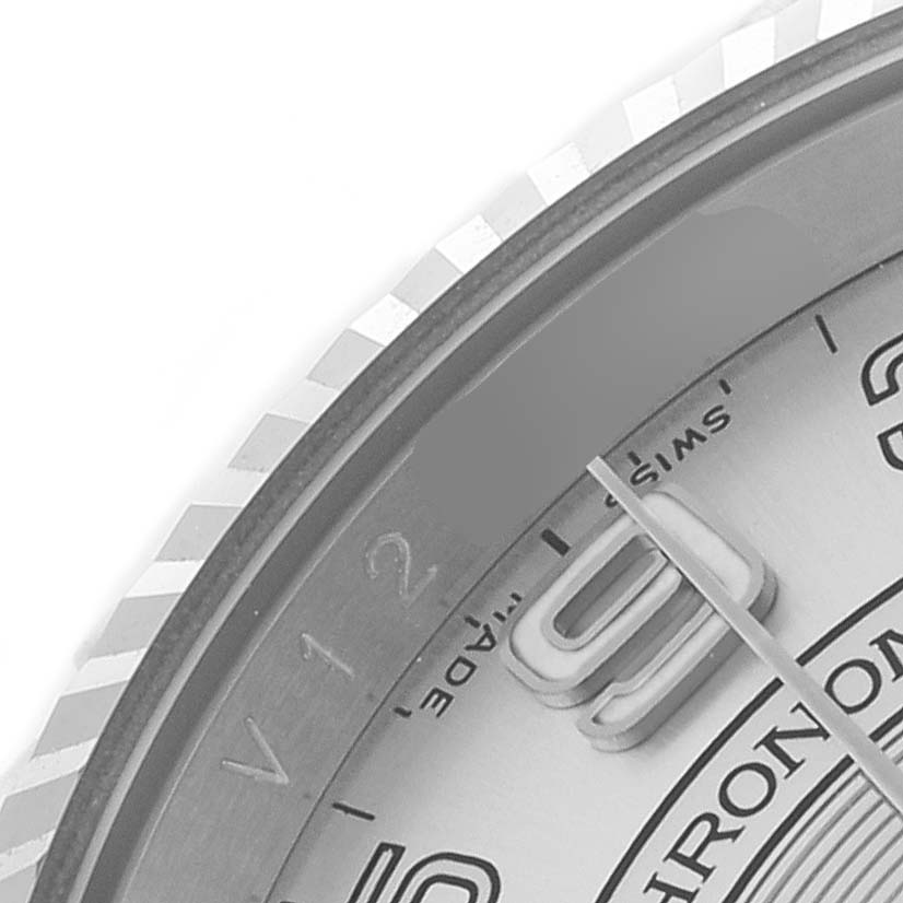 The image shows a close-up of the Rolex Oyster Perpetual 116034 Men's Stainless Steel Silver Dial watch, focusing on part of the dial, bezel, and a hand.