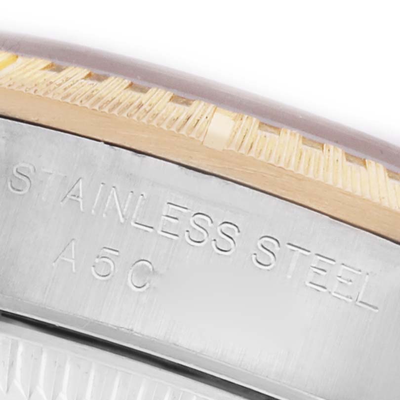 The image shows a close-up of the side of a Rolex Oyster Perpetual 76243 Women's Steel and Gold (two tone) Black Dial 76243 Women's Steel and Gold (two tone) Black Dial, highlighting the stainless steel engraving.