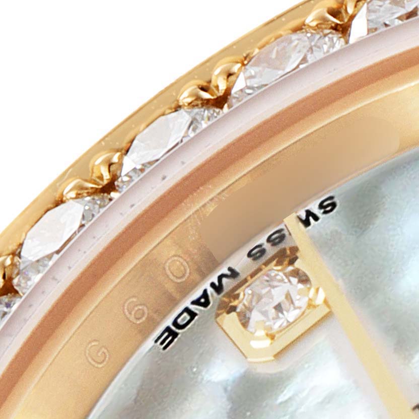 This close-up image of the Rolex Pearlmaster 80298 Women's Yellow Gold Mother of Pearl Dial 80298 Women's Yellow Gold Mother of Pearl Dial watch shows a partial view of the bezel adorned with diamonds and part of the dial indicating "Swiss Made."