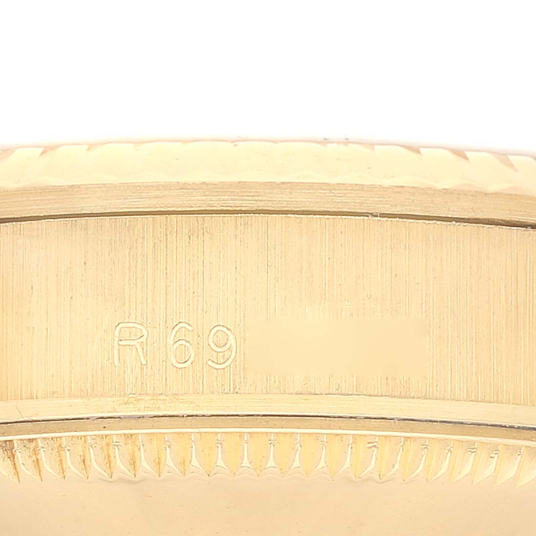 The image shows a close-up of the engravings on the side of a Rolex President 68278 Women's Yellow Gold Black Dial 68278 Women's Yellow Gold Black Dial watch case.