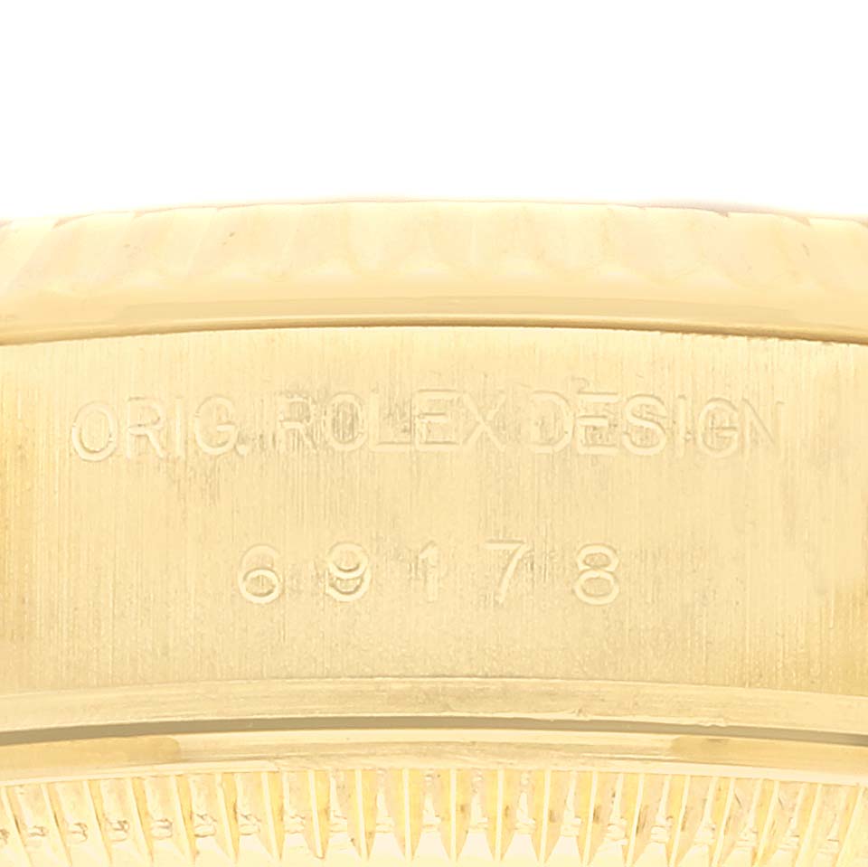 The image shows a close-up of the side of a Rolex President 69178 Women's Yellow Gold Champagne Dial 69178 Women's Yellow Gold Champagne Dial model, highlighting the engraved serial and model number.