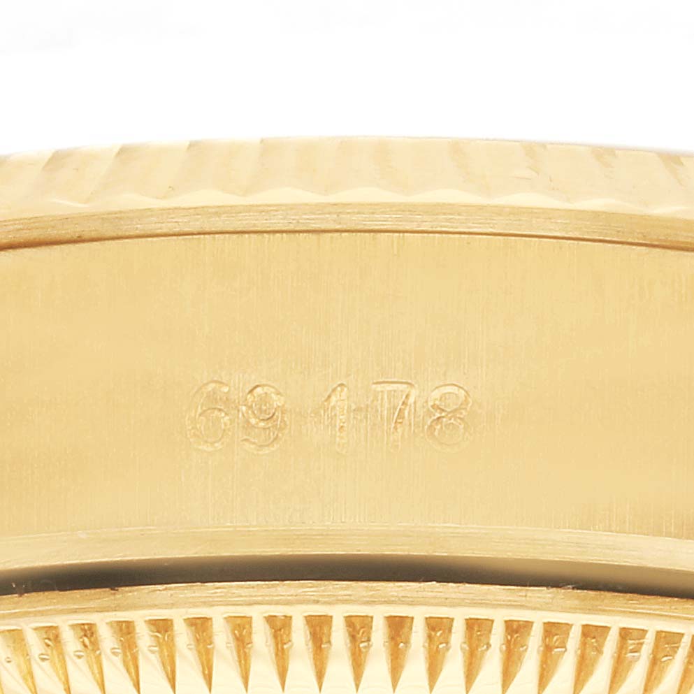 The image shows a close-up side view of the case of a Rolex President 69178 Women's Yellow Gold Champagne Dial 69178 Women's Yellow Gold Champagne Dial model, highlighting the engraved numbers.