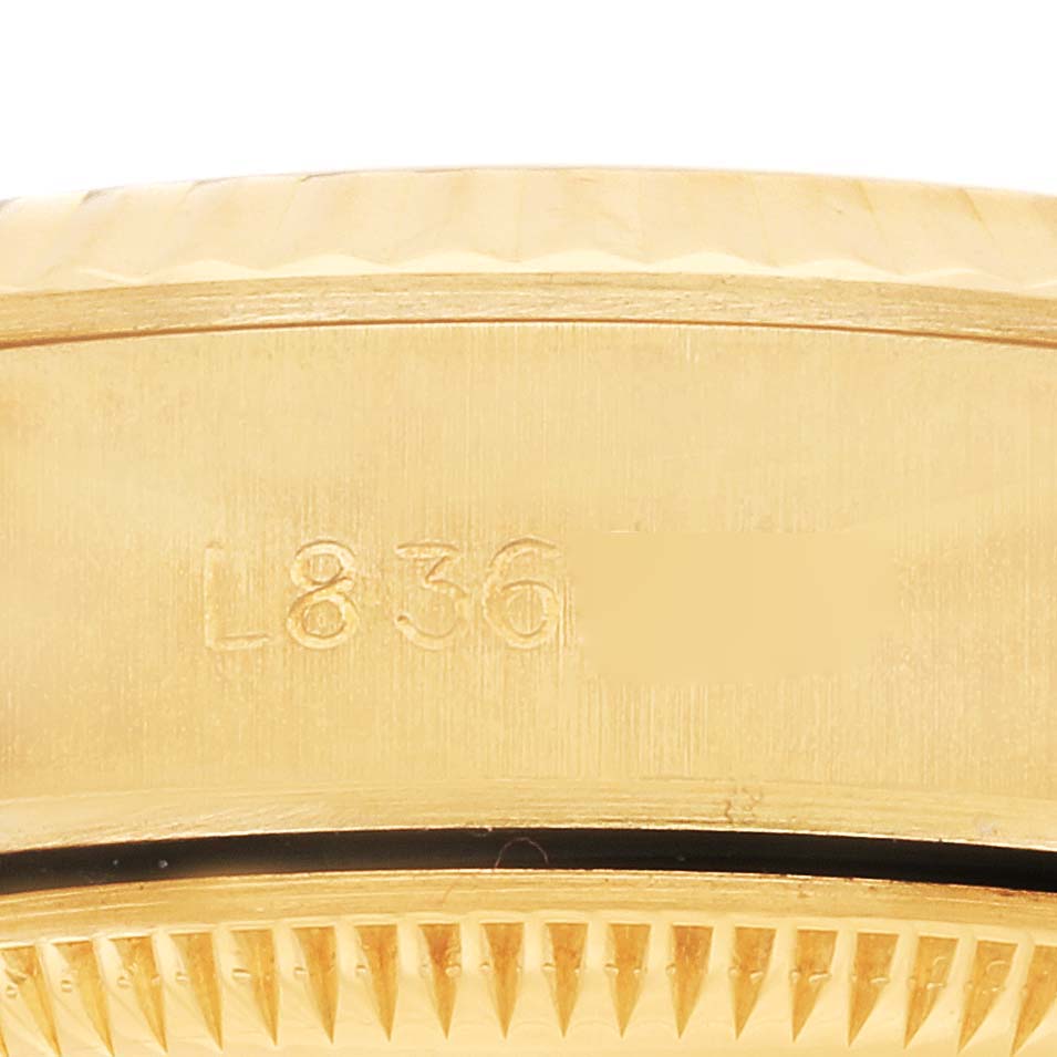 The image shows a detailed close-up of the side of a Rolex President 69178 Women's Yellow Gold Champagne Dial 69178 Women's Yellow Gold Champagne Dial model, highlighting the bezel edge and engraved serial numbers.