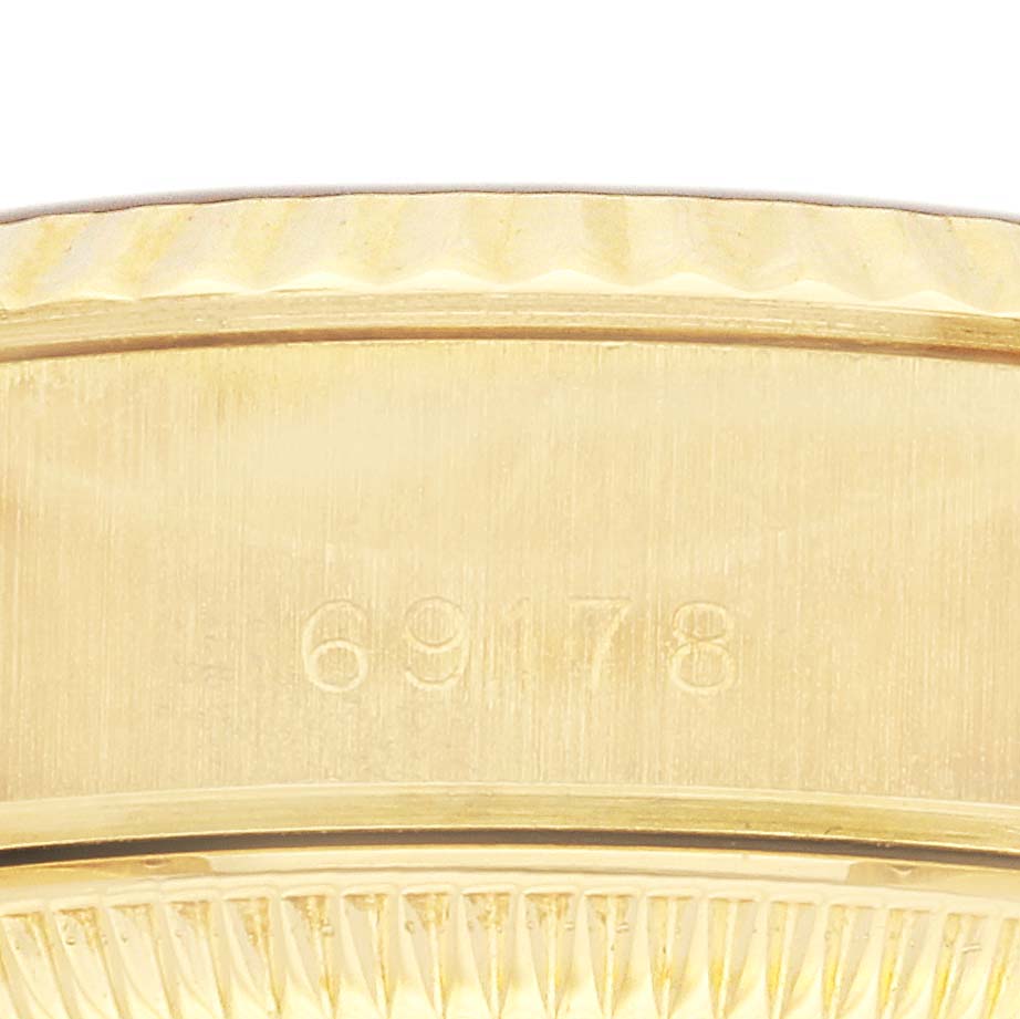 The image shows a close-up of the side view of the Rolex President 69178 Women's Yellow Gold Champagne Dial 69178 Women's Yellow Gold Champagne Dial model, focusing on the engraved serial number area.