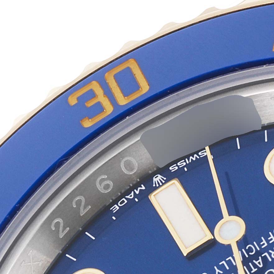 This close-up image shows the blue bezel, minute hand, and part of the dial of a Rolex Submariner 126613 Men's Steel and Gold (two tone) Blue Dial 126613 Men's Steel and Gold (two tone) Blue Dial watch.