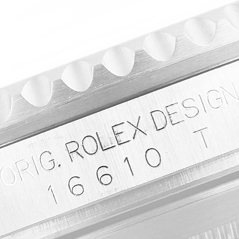 The image shows a close-up of the engraved side of a Rolex Submariner 16610 Men
s Stainless Steel Black Dial 16610 Men
s Stainless Steel Black Dial model, highlighting the bezel and inscribed model number 16610.