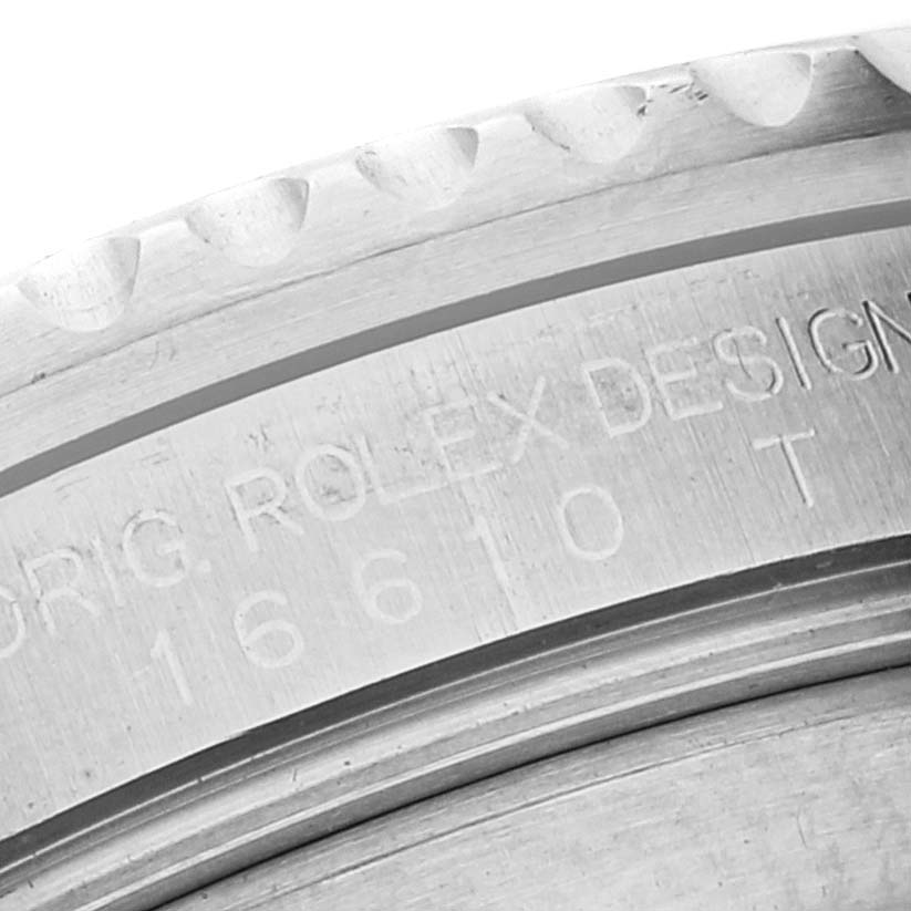 The image shows a close-up of the engraving on the bezel and rehaut of a Rolex Submariner 16610 Men's Stainless Steel Black Dial 16610 Men's Stainless Steel Black Dial watch.