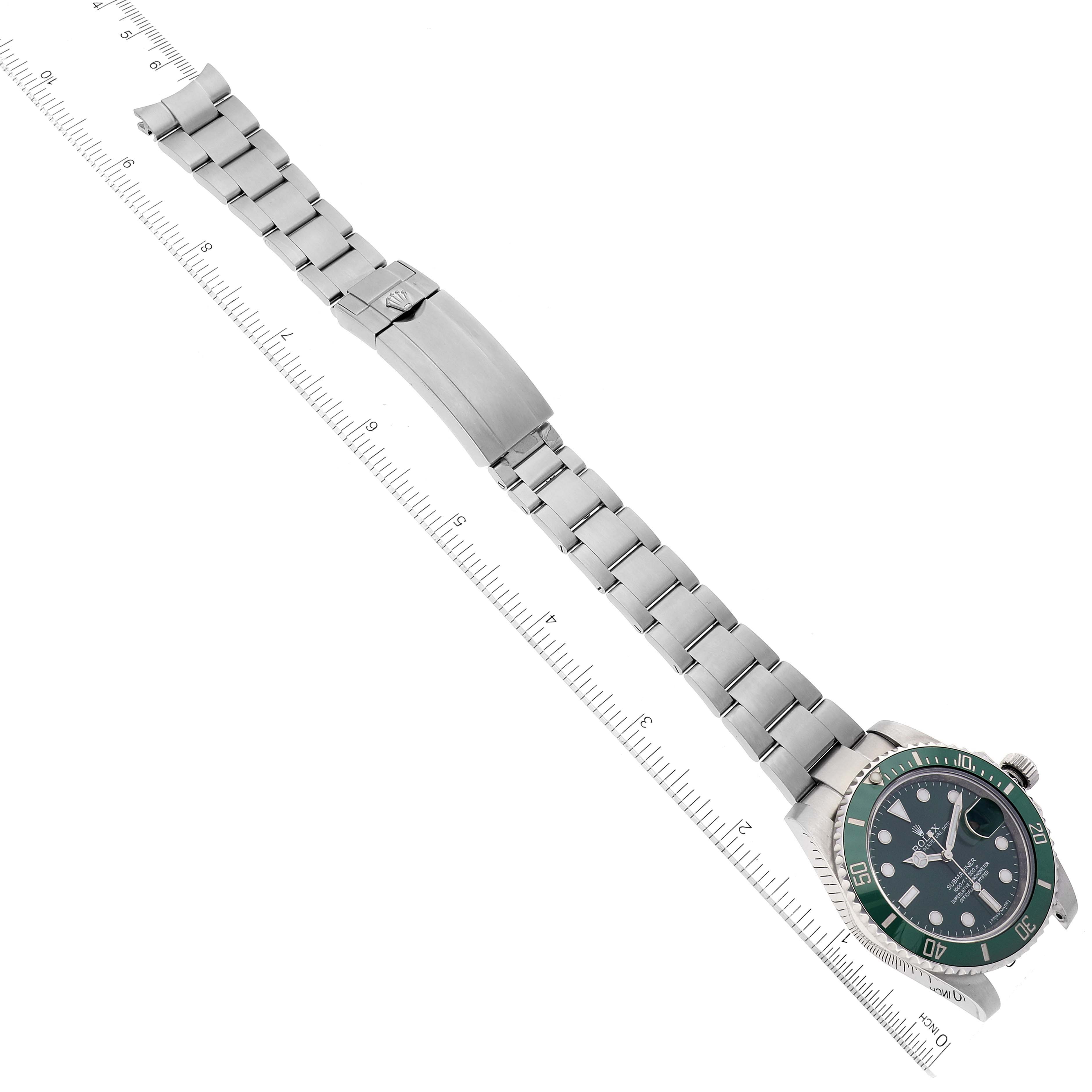 The image shows a top-down view of a Rolex Submariner 116610LV Men's Stainless Steel Green Dial 116610LV Men's Stainless Steel Green Dial watch and its stainless steel bracelet alongside a measuring ruler.