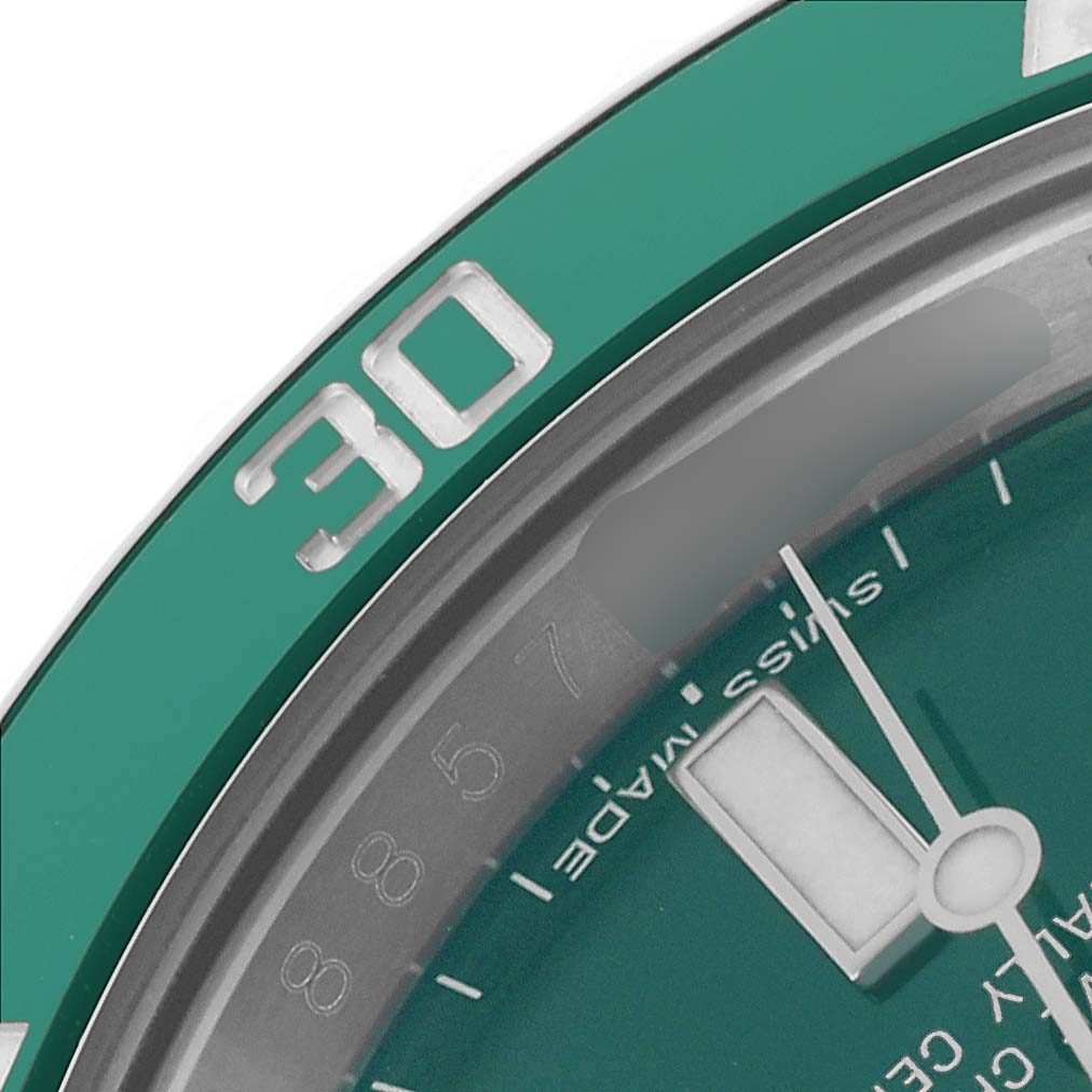 The image shows a close-up of the Rolex Submariner 116610LV Men's Stainless Steel Green Dial 116610LV Men's Stainless Steel Green Dial's bezel at the 30 mark and part of the dial with a hand and indices.