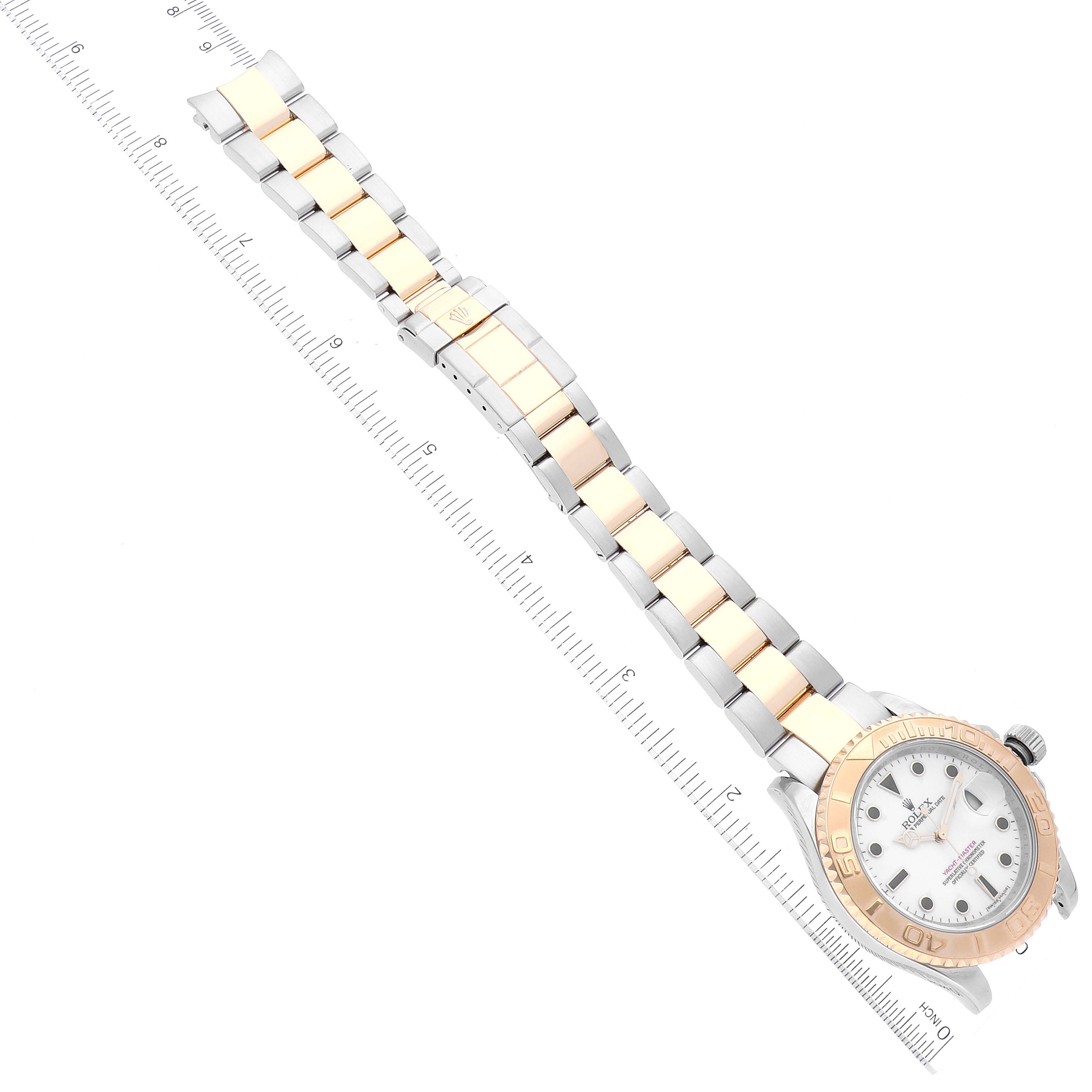 The Rolex Yacht-Master 16623 Men
s Steel and Gold (two tone) White Dial 16623 Men
s Steel and Gold (two tone) White Dial watch is shown from the front with its full bracelet and clasp visible, positioned next to a ruler for scale.