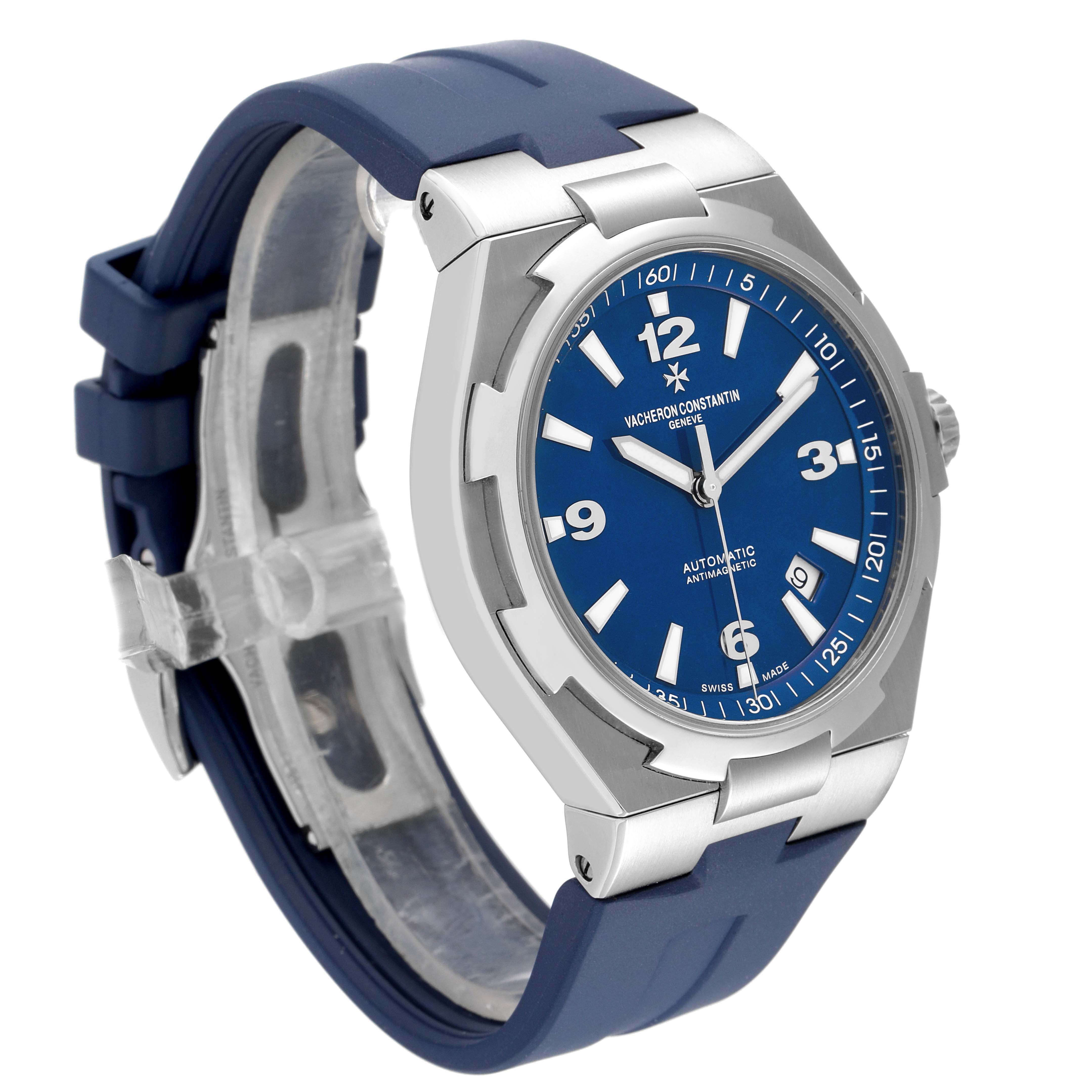 The Vacheron Constantin Overseas 47040/000A-9008 Men's Stainless Steel Blue Dial watch is shown from a front-left angle, displaying its blue dial, stainless steel case, and blue strap.
