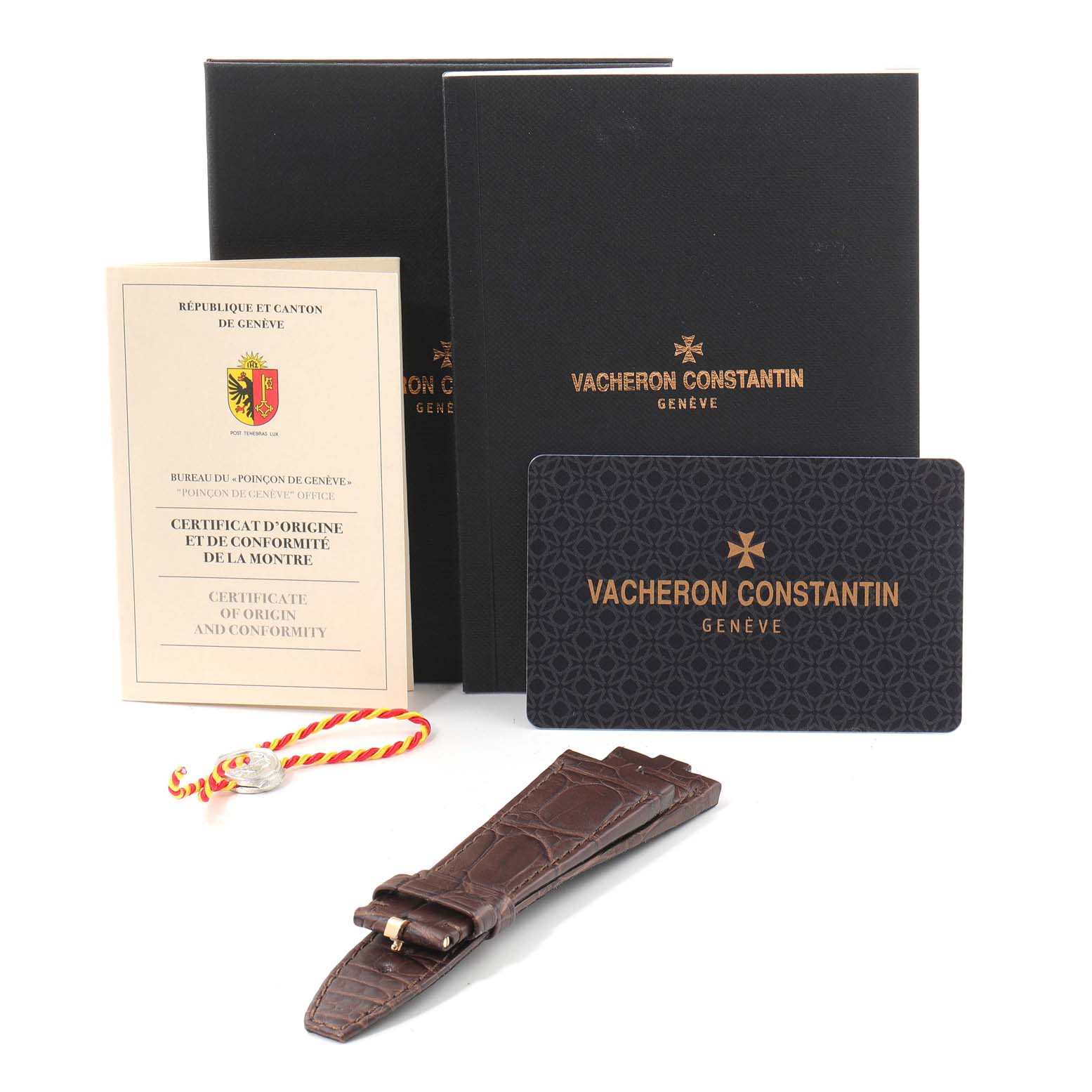 The image shows the accessories of a Vacheron Constantin Overseas 7900V/000R-B336 Men's Rose Gold Silver Dial 7900V/000R-B336 Men's Rose Gold Silver Dial watch, including documentation, a card, and an additional strap.