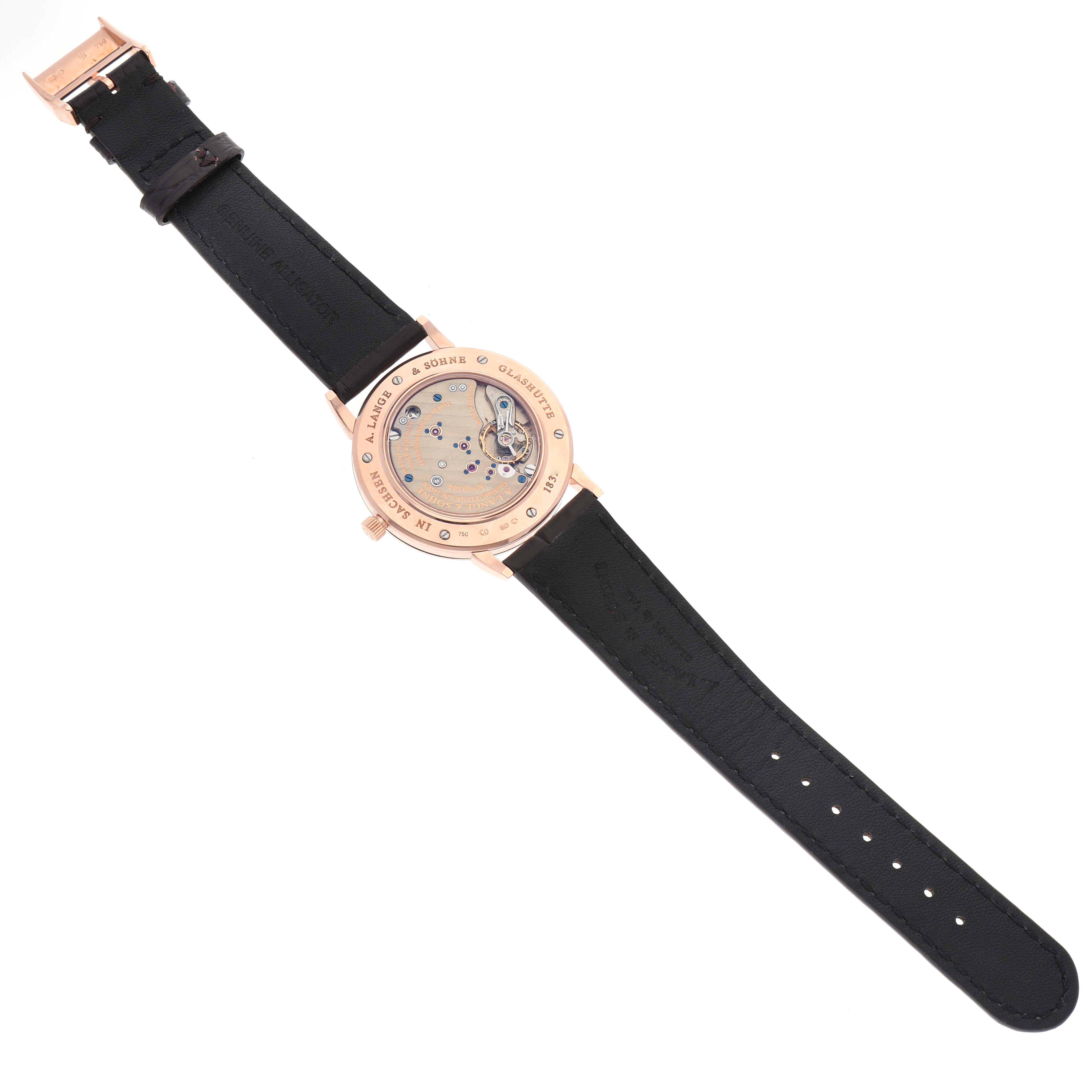 The image shows the back view of an A. Lange & Sohne Saxonia 215.032 Men's Rose Gold Silver Dial watch, displaying its movement and black leather strap.