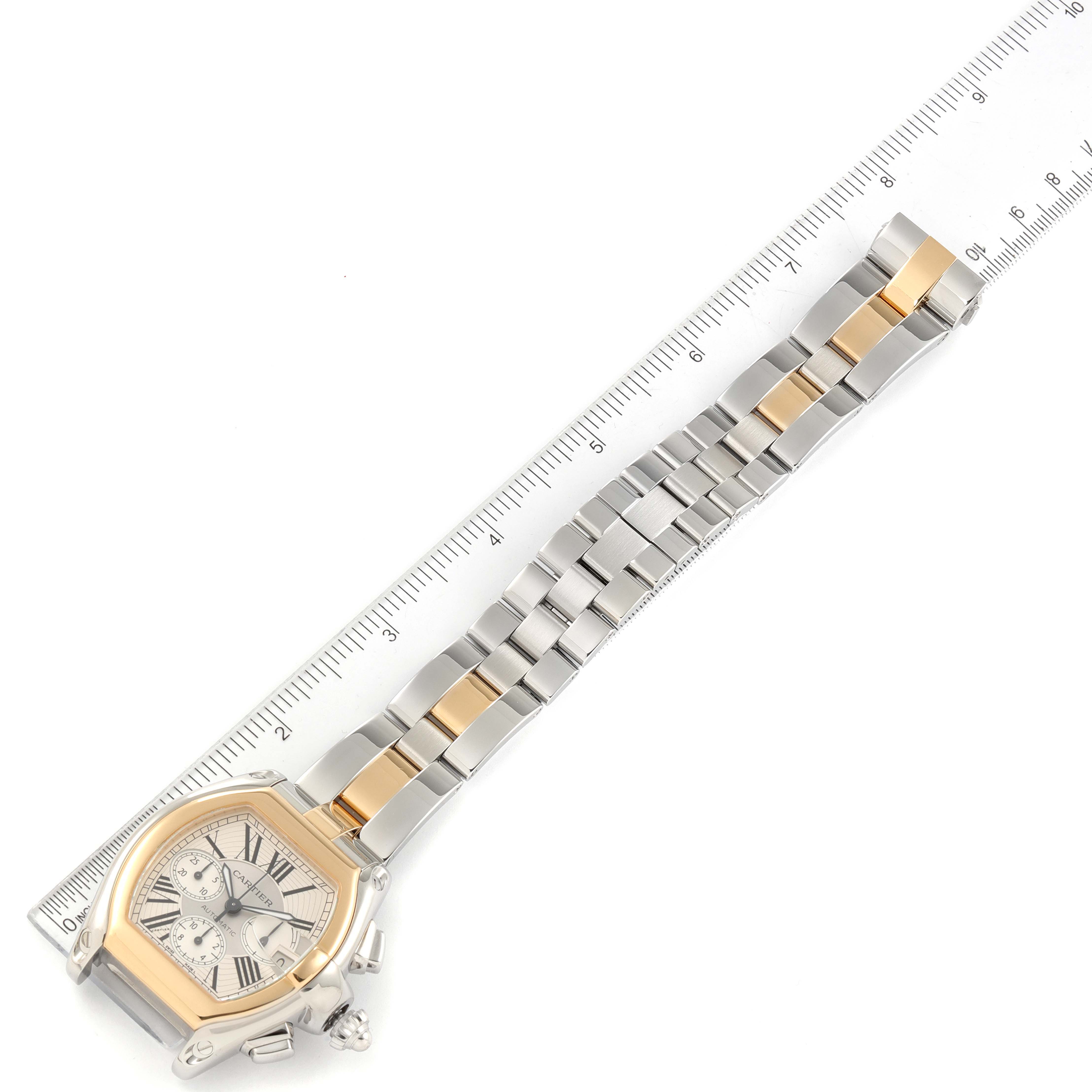 The image shows a Cartier Roadster W62027Z1 Men
s Steel and Gold (two tone) Silver Dial W62027Z1 Men
s Steel and Gold (two tone) Silver Dial watch with its bracelet extended alongside a ruler for measurement.