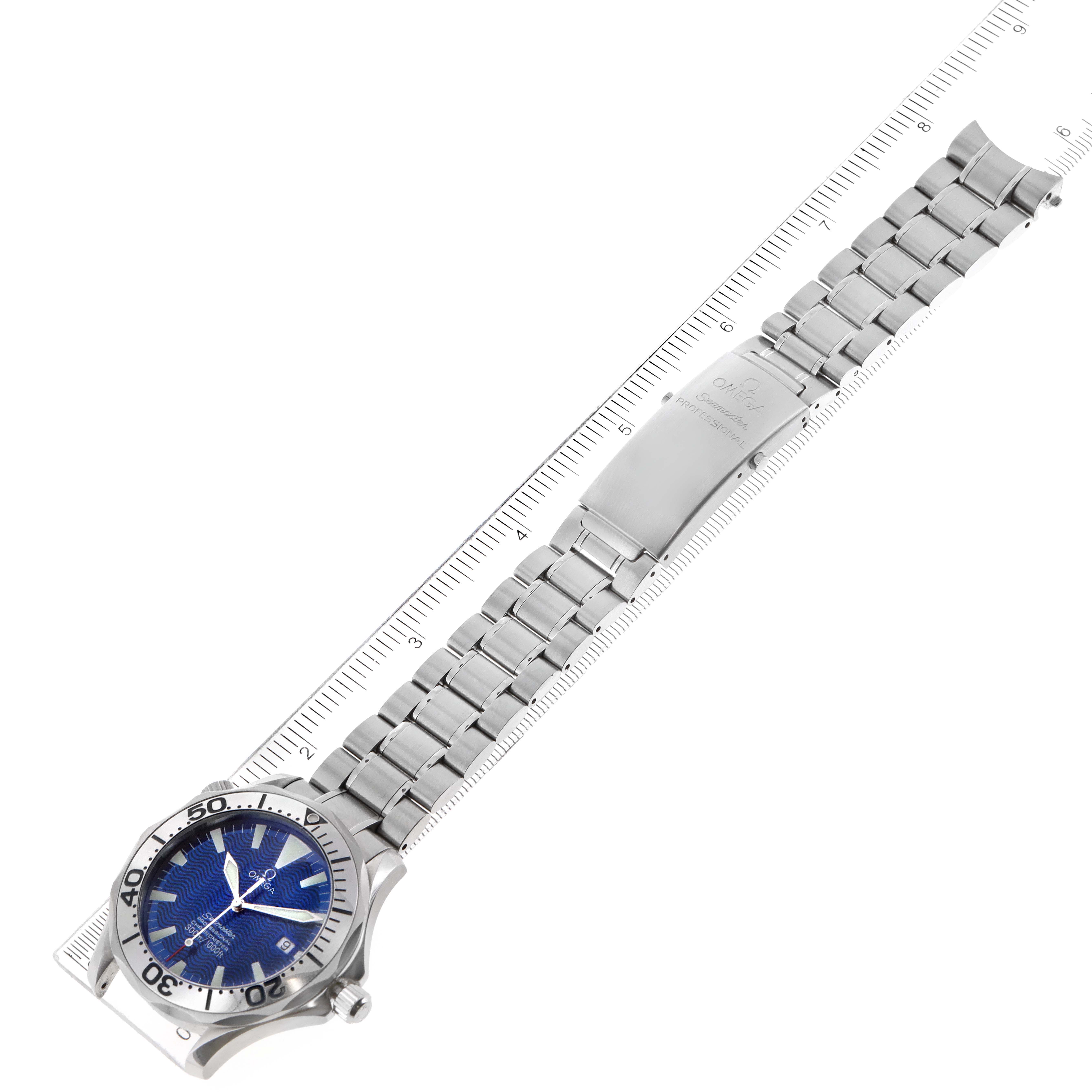 The image shows an overhead view of the Omega Seamaster 2255.80.00 Men
s Stainless Steel Blue Dial 2255.80.00 Men
s Stainless Steel Blue Dial watch with a blue dial and metal bracelet, displayed alongside a ruler.