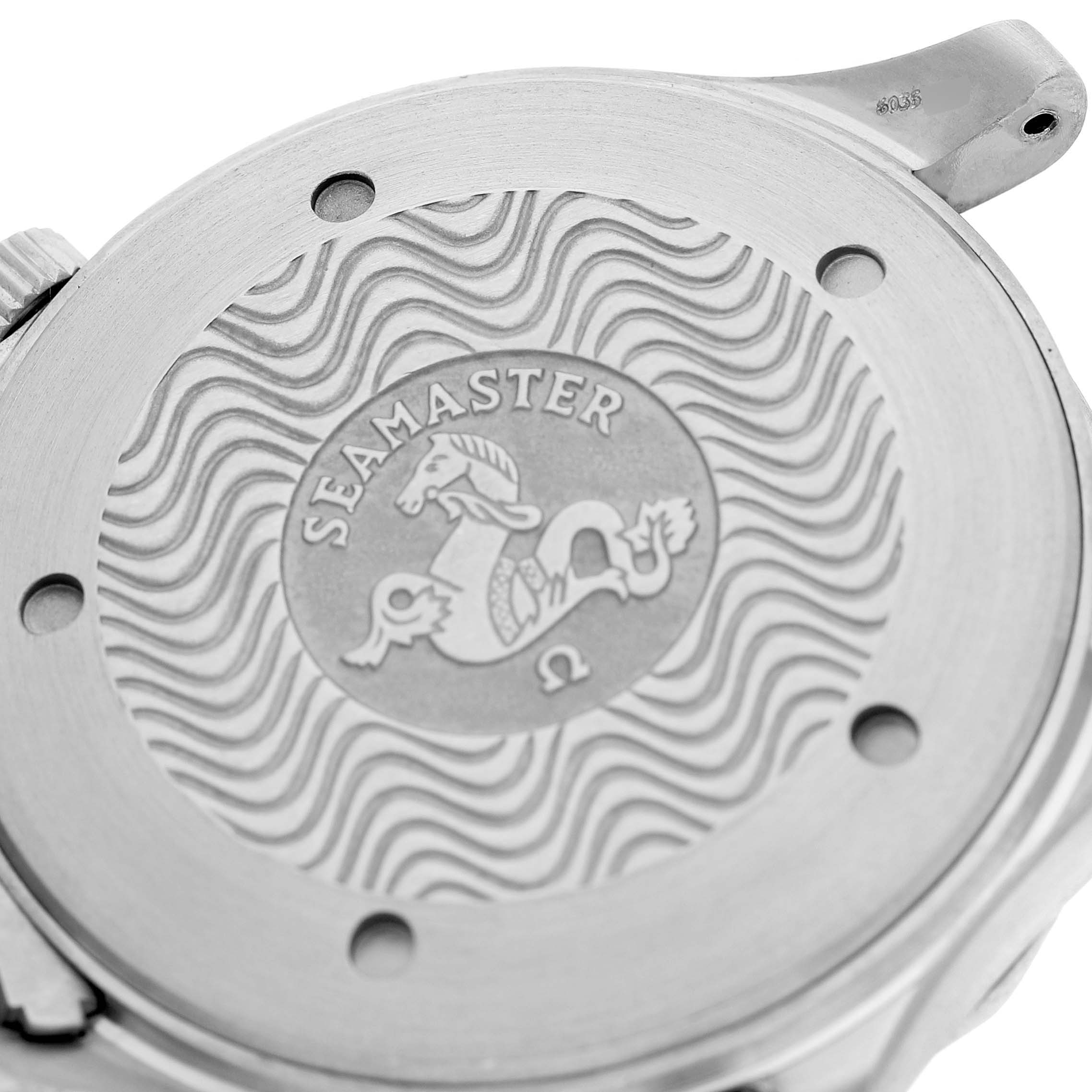 The image shows the back of an Omega Seamaster 2231.80.00 Men's Titanium Blue Dial watch with its engraved logo and wave pattern.