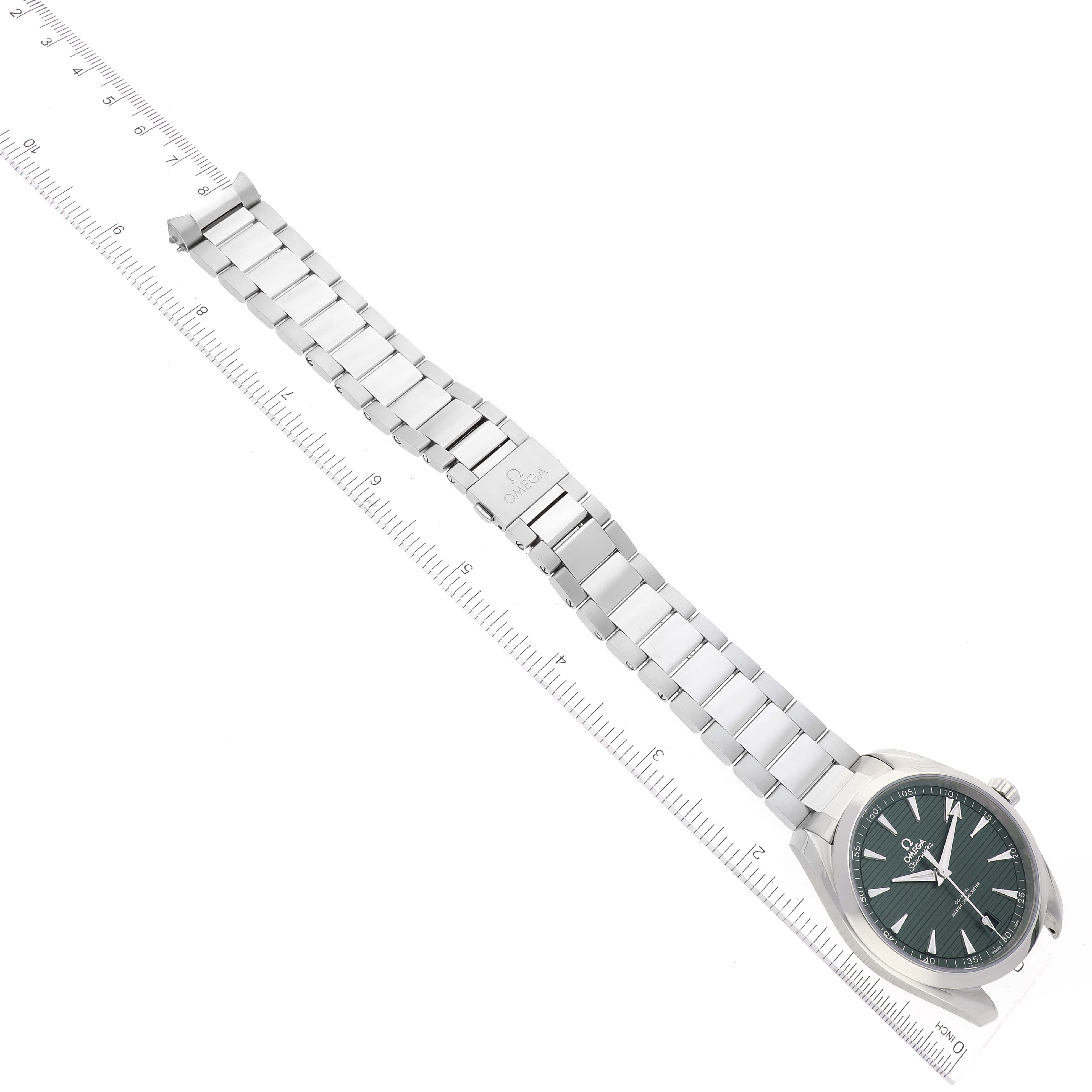The image shows an Omega Aqua Terra 220.10.41.21.10.001 Men's Stainless Steel Green Dial 220.10.41.21.10.001 Men's Stainless Steel Green Dial watch laid flat with its metal bracelet fully extended, alongside a ruler for scale.