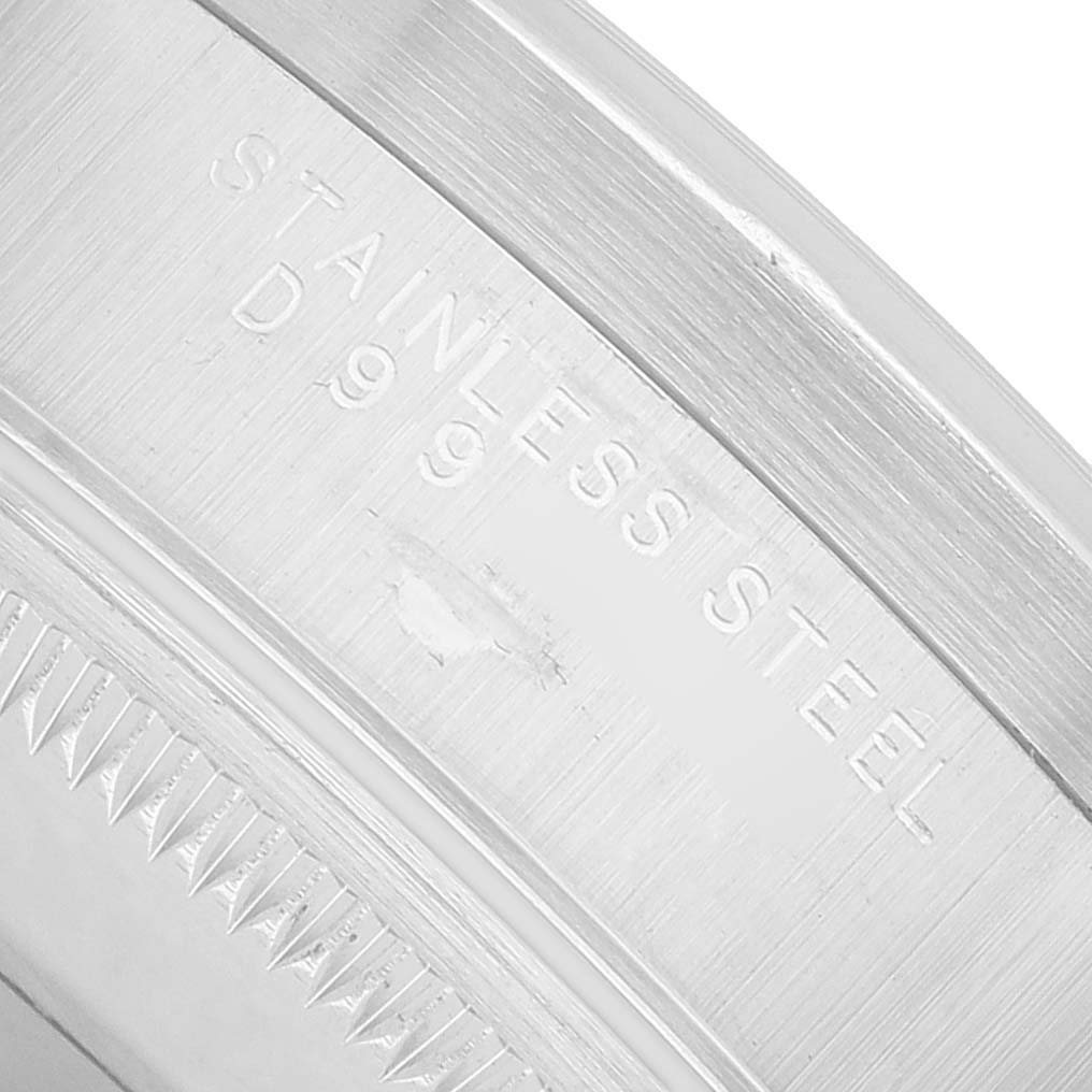 The image shows a close-up angle of the inner bezel's engraving on a Rolex Date 15210 Men's Stainless Steel Silver Dial model watch, focusing on the "STAINLESS STEEL" text.