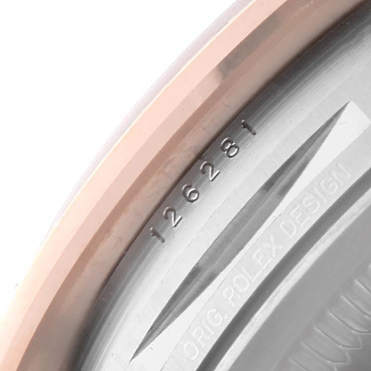 This close-up image shows the engraved serial number and part of the bezel of a Rolex Datejust 126281 Men's Steel and Gold (two tone) Brown Dial 126281 Men's Steel and Gold (two tone) Brown Dial watch.