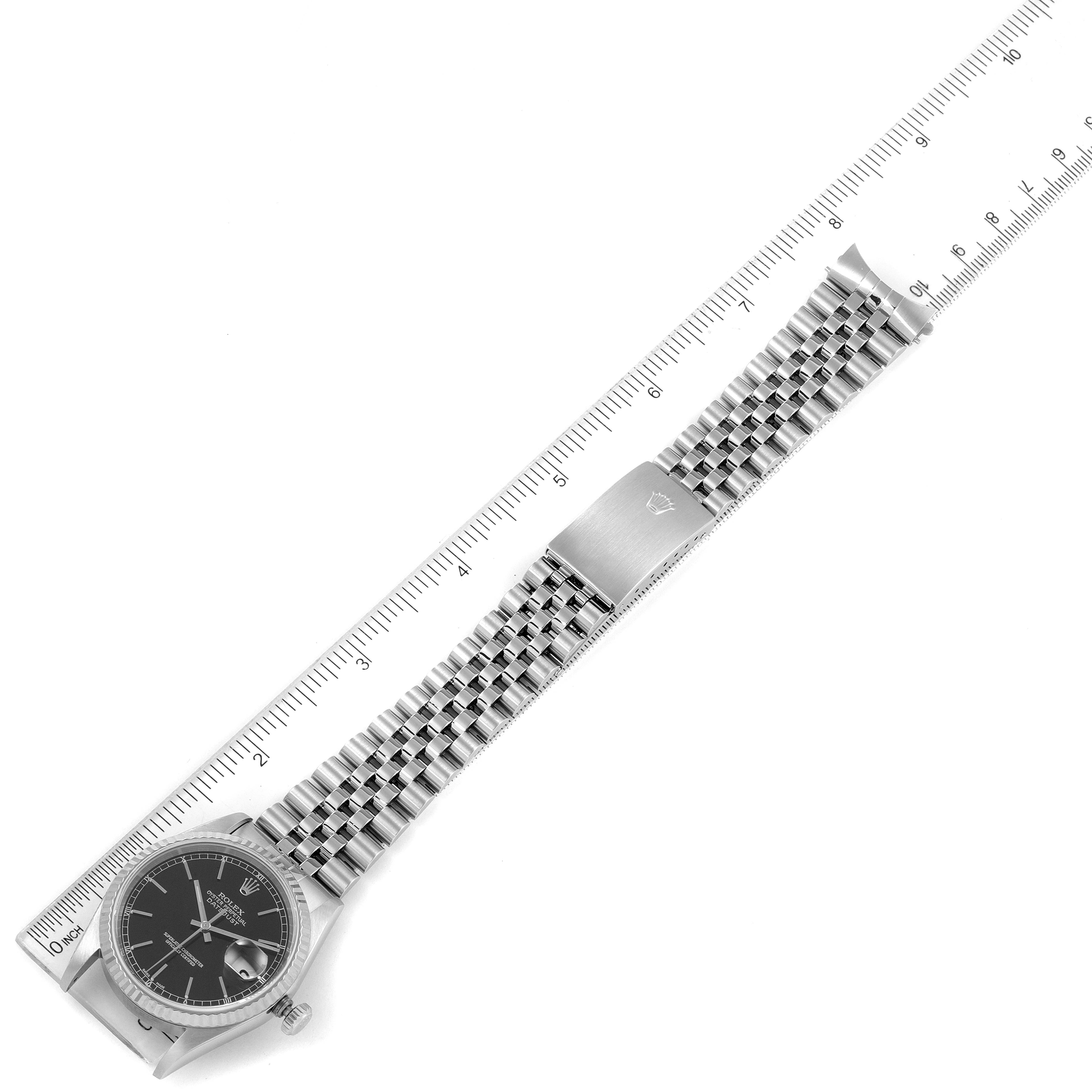The image shows the Rolex Datejust 16234 Men
s Stainless Steel Black Dial 16234 Men
s Stainless Steel Black Dial watch laid flat with its bracelet and clasp visible, next to a ruler for measurement.