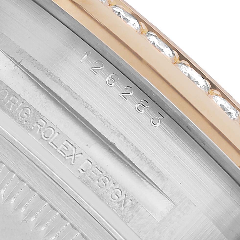 The image shows a close-up of the Rolex Datejust 126283RBR Men's Steel and Gold (two tone) Silver Dial model's bezel and part of the case, featuring the model number and 'Rolex Design' engraving.