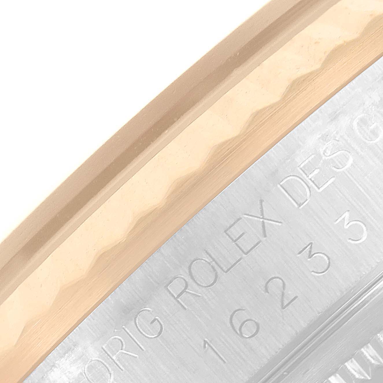 The image shows a close-up of the bezel and engraved side of the case of a Rolex Datejust 16233 Men's Steel and Gold (two tone) Champagne Dial 16233 Men's Steel and Gold (two tone) Champagne Dial watch.