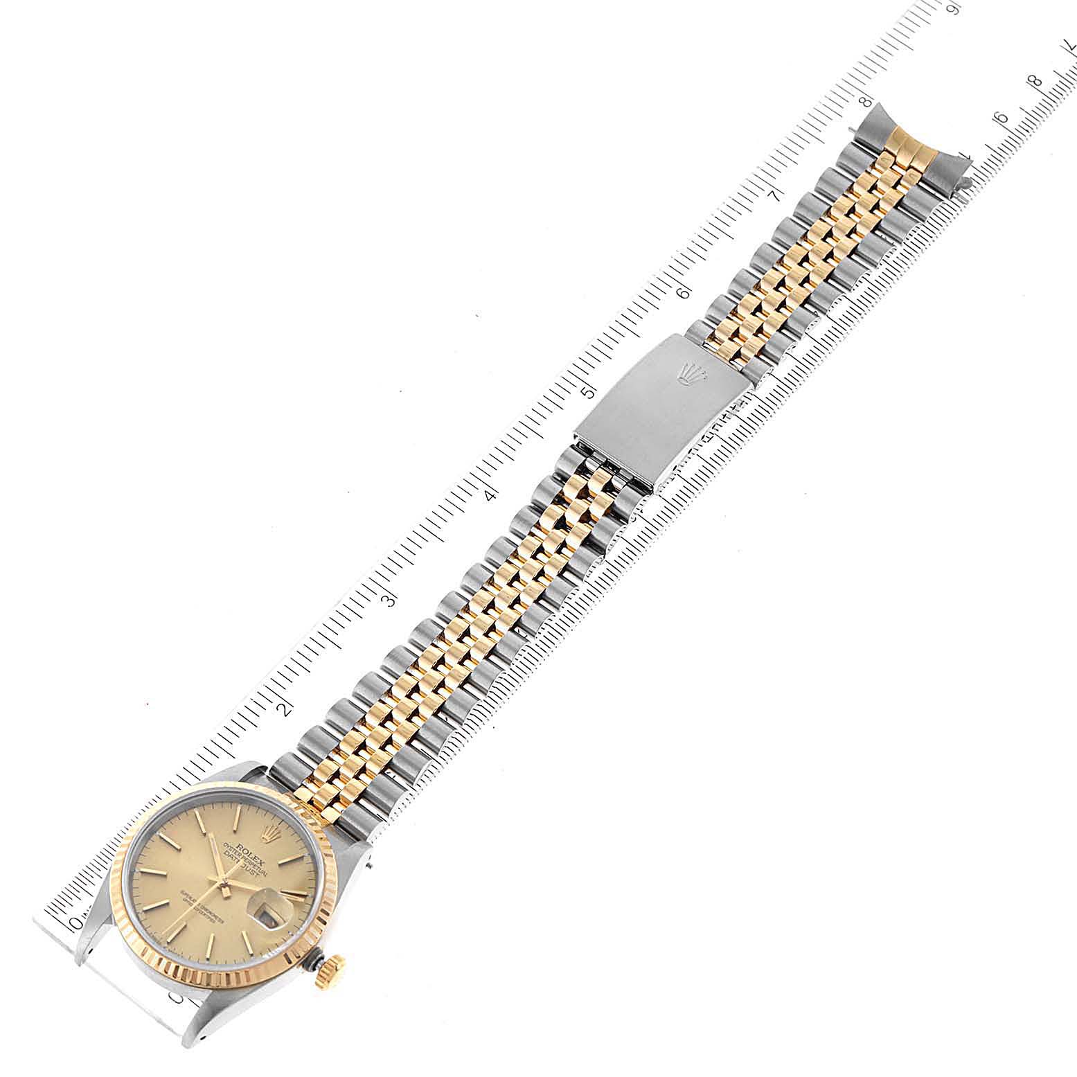 The image shows a top-down view of a Rolex Datejust 16233 Men's Steel and Gold (two tone) Champagne Dial 16233 Men's Steel and Gold (two tone) Champagne Dial watch, highlighting the face, crown, and two-tone jubilee bracelet with a ruler alongside it.