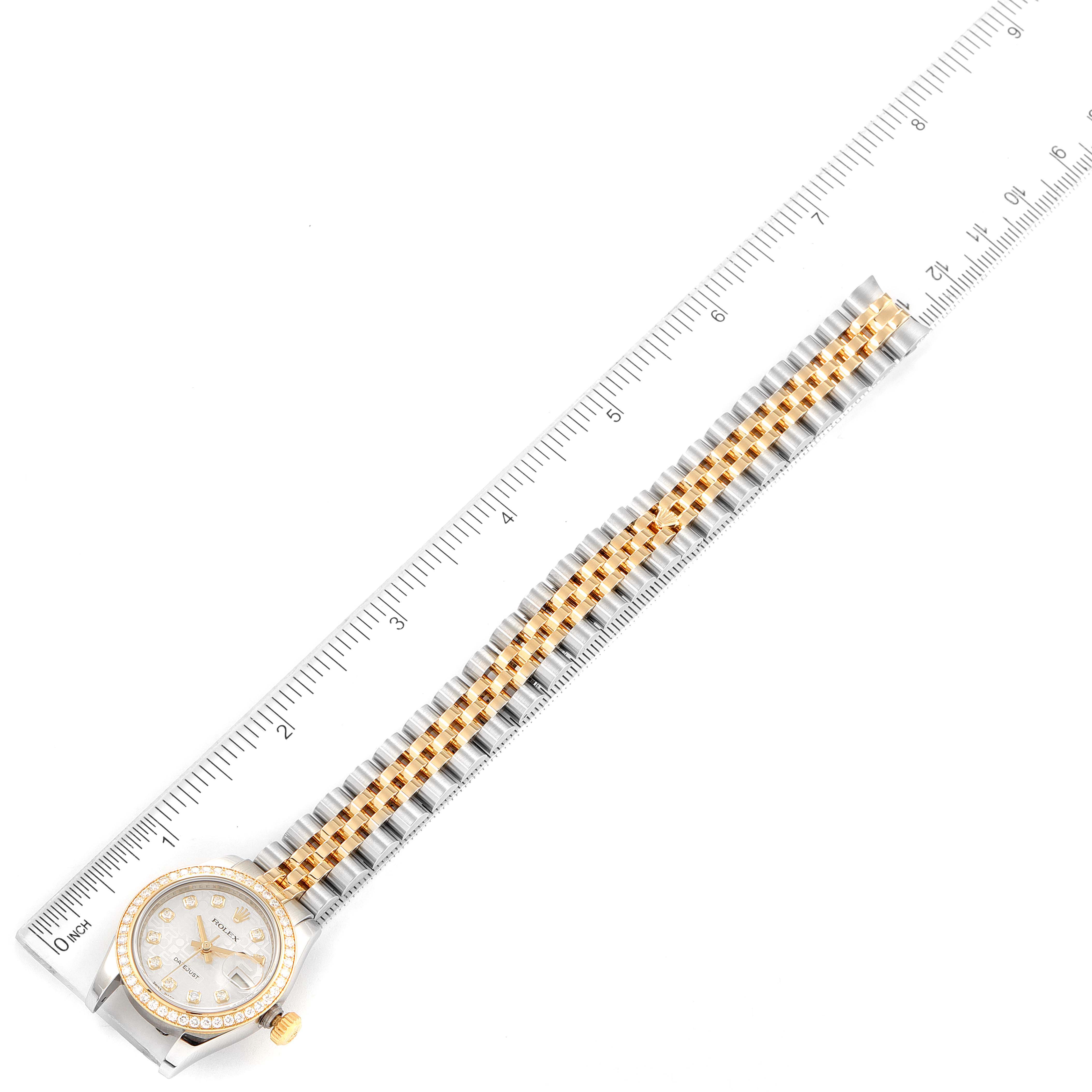 The Rolex Datejust 179383 Women
s Steel and Gold (two tone) Silver Dial 179383 Women
s Steel and Gold (two tone) Silver Dial watch is shown from a top-down angle, displaying the face, bezel, and full length of the bracelet alongside a ruler.