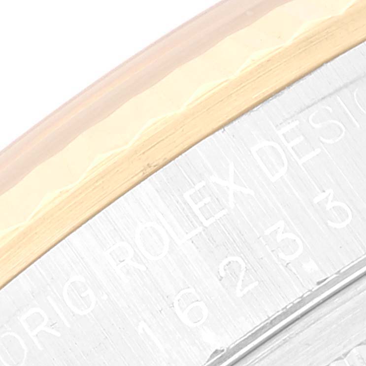 This image shows a close-up of the engraved edge of a Rolex Datejust 16233 Men's Steel and Gold (two tone) Champagne Dial 16233 Men's Steel and Gold (two tone) Champagne Dial watch, highlighting some text and the bezel.