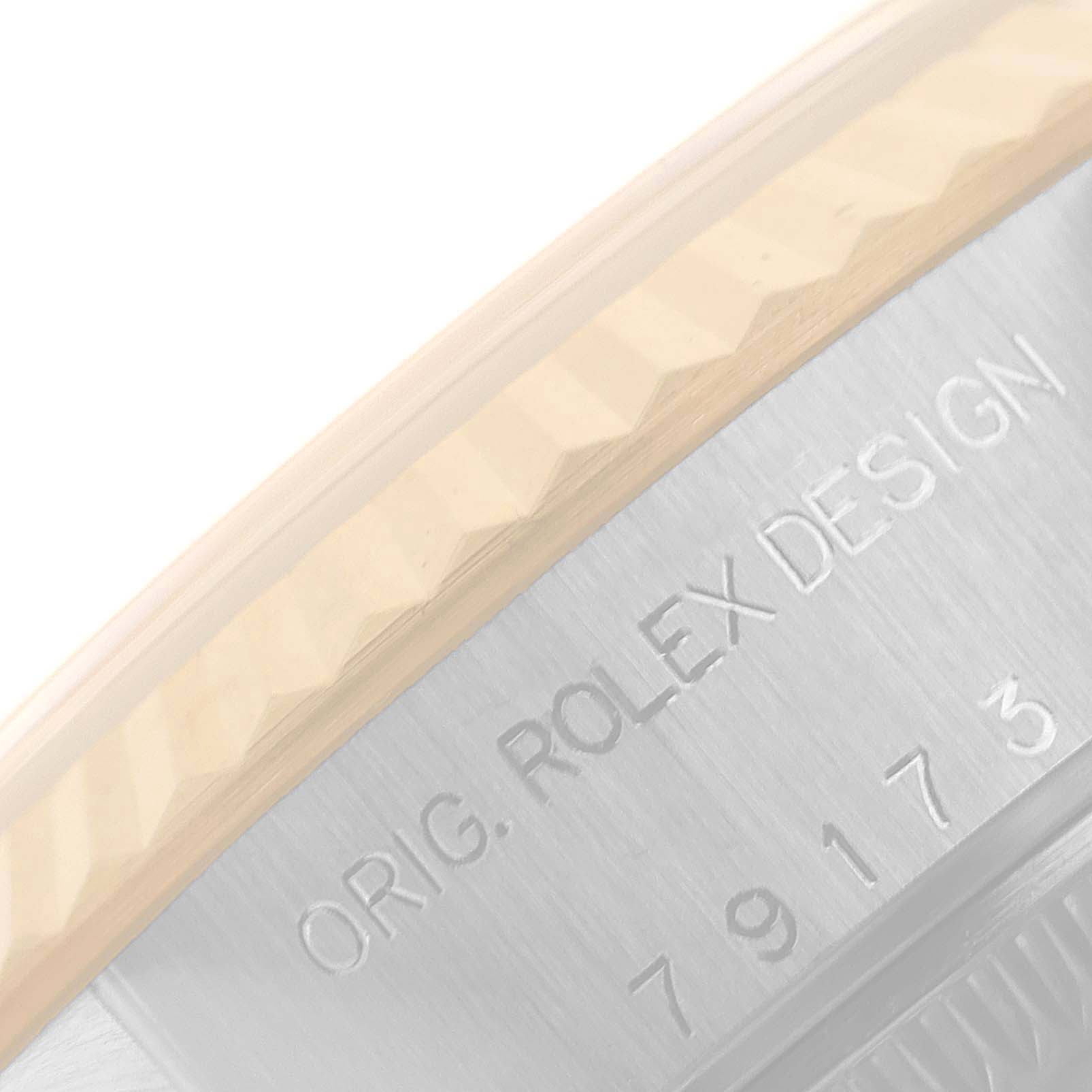 The image shows a close-up of the engraved case side and fluted bezel of a Rolex Datejust 79173 Women
s Steel and Gold (two tone) Champagne Dial 79173 Women
s Steel and Gold (two tone) Champagne Dial watch.