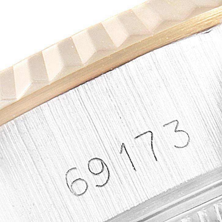 The image shows a close-up angle of the serial number engraved on the side of the Rolex Datejust 69173 Men's Steel and Gold (two tone) Silver Dial 69173 Men's Steel and Gold (two tone) Silver Dial model watch, near the fluted bezel.