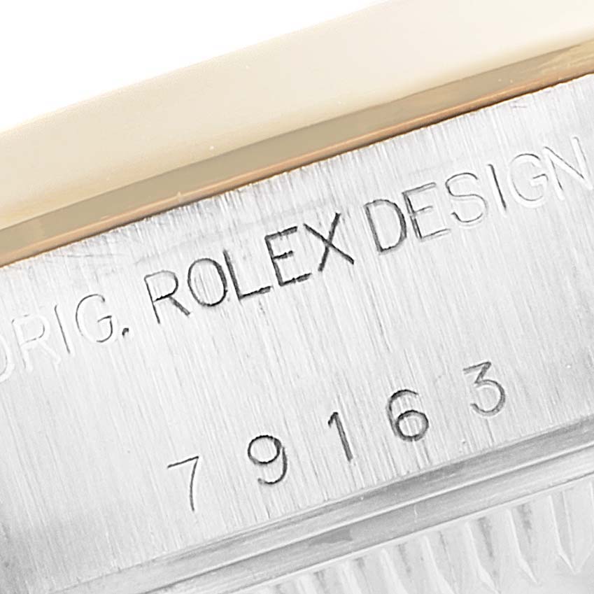 This close-up image shows the serial number and "ROLEX DESIGN" text on the case of a Rolex Datejust 79163 Women's Steel and Gold (two tone) Grey Dial 79163 Women's Steel and Gold (two tone) Grey Dial watch.