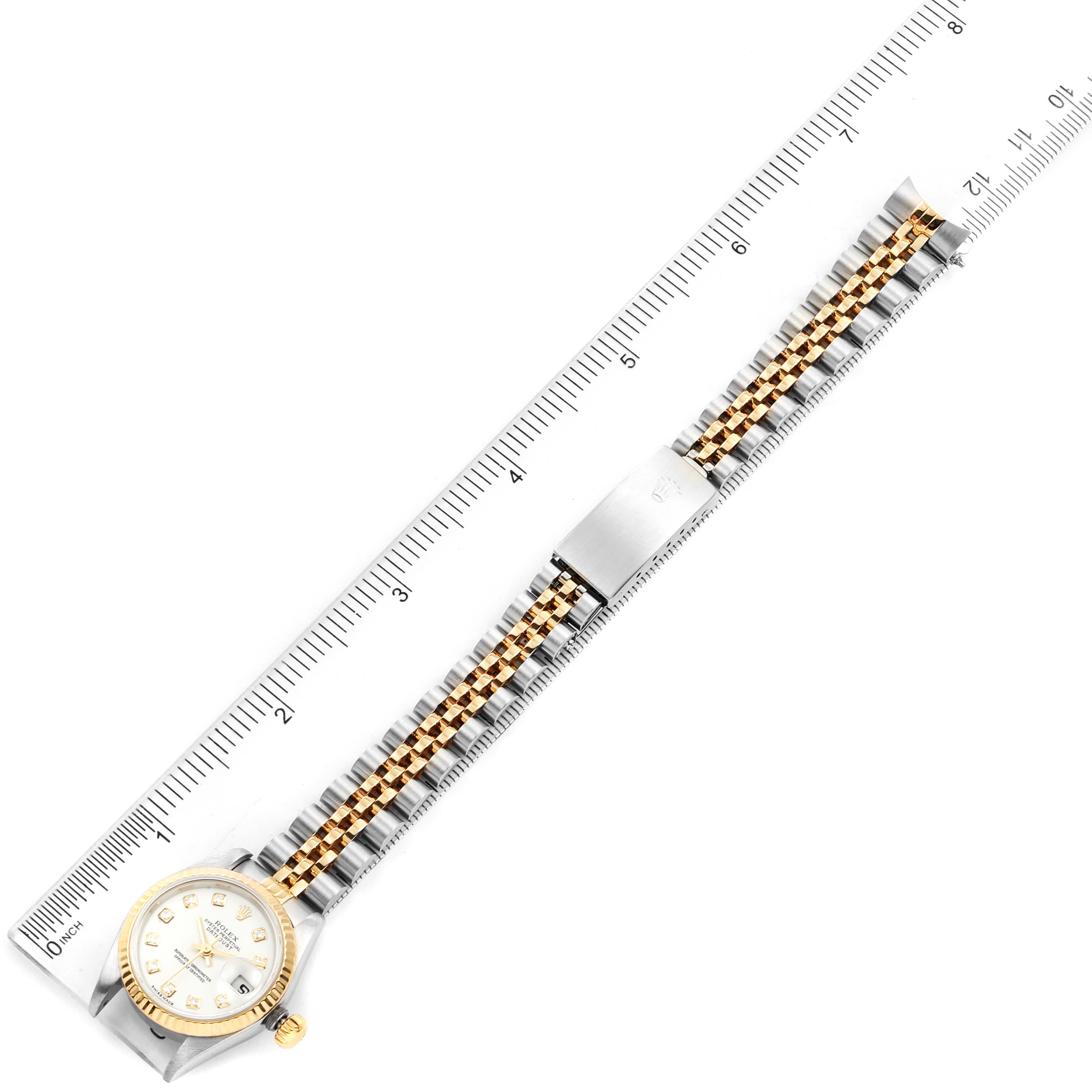 The image shows a Rolex Datejust 79173 Women's Steel and Gold (two tone) White Dial 79173 Women's Steel and Gold (two tone) White Dial watch laid flat with a ruler, displaying the face, bracelet, and clasp from a top-down angle.
