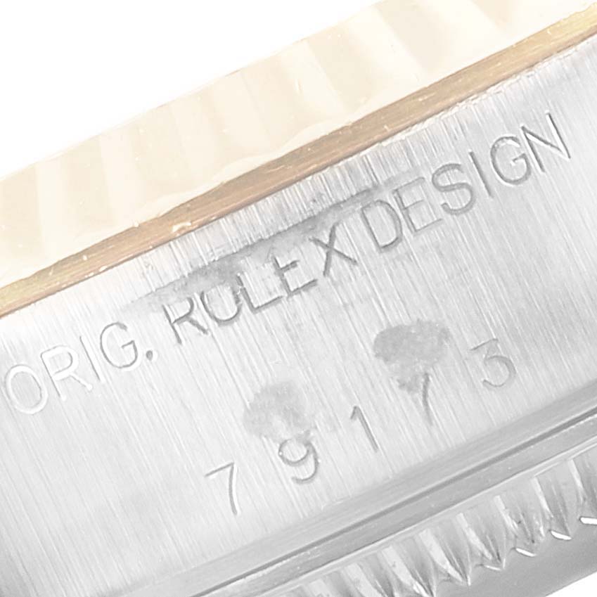 The image shows a close-up of the serial number and "ORIG. ROLEX DESIGN" engraving on the side of a Rolex Datejust 79173 Women's Steel and Gold (two tone) White Dial 79173 Women's Steel and Gold (two tone) White Dial watch case.