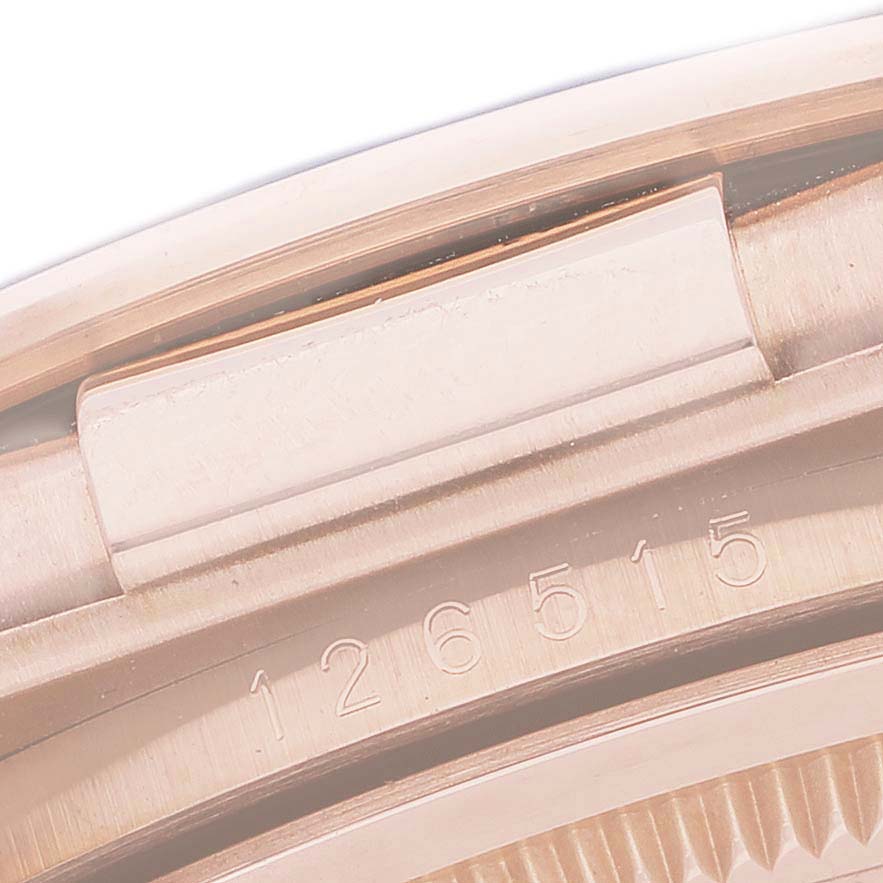 The image shows a detailed close-up of the bezel edge and case number engraving on a Rolex Daytona 126515LN Men's Rose Gold Black Dial watch.