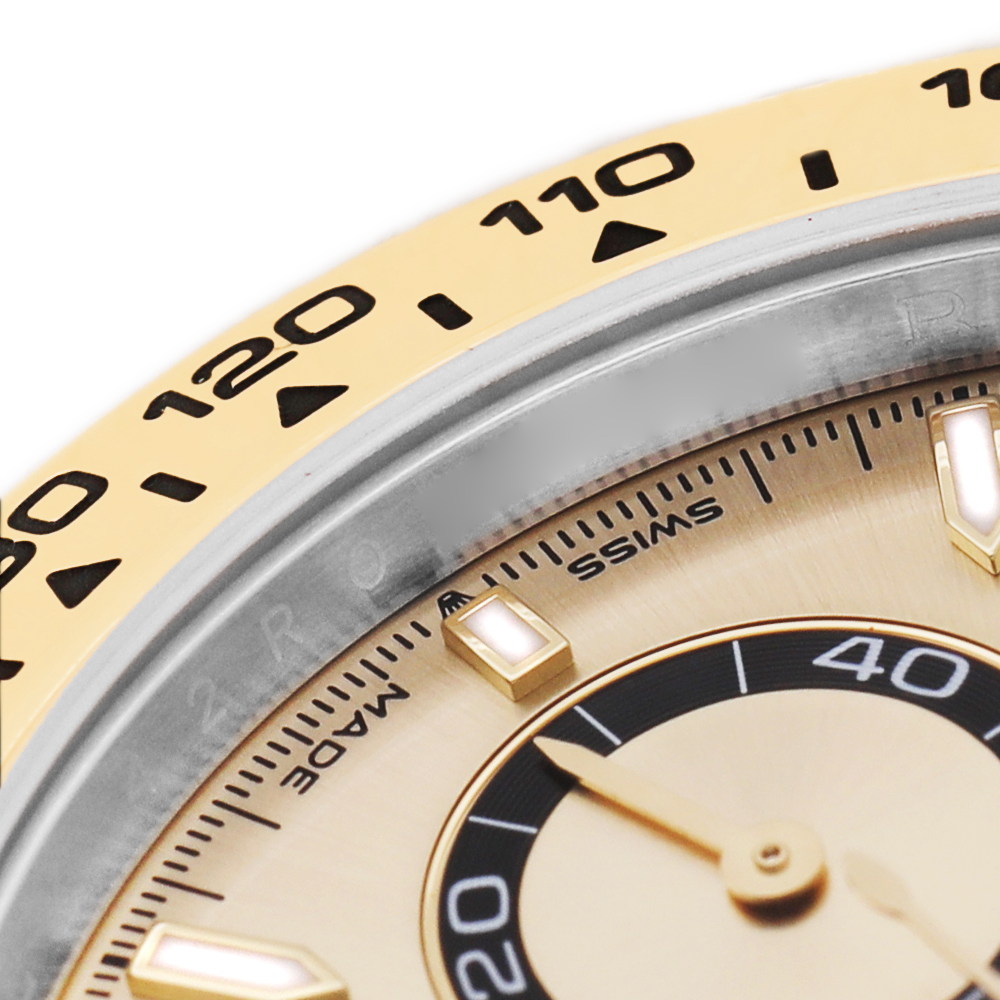 The image shows a close-up of the Rolex Daytona 126503 Men's Steel and Gold (two tone) Champagne Dial's bezel with tachymetric scale and part of the dial with hour markers.