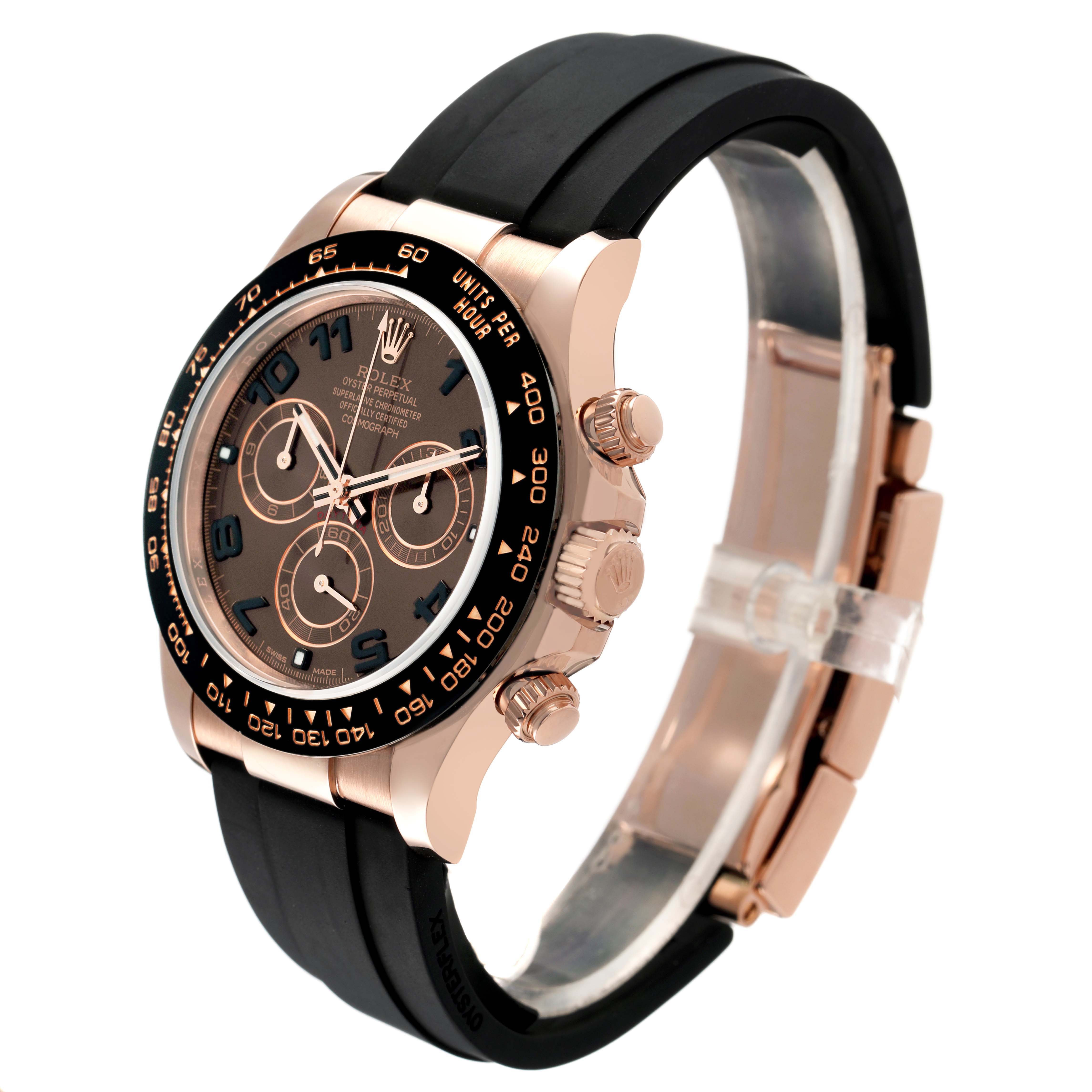 The image shows a side angle of the Rolex Daytona 116515LN Mens Rose Gold Brown Dial, highlighting the bezel, pushers, crown, and rubber strap.