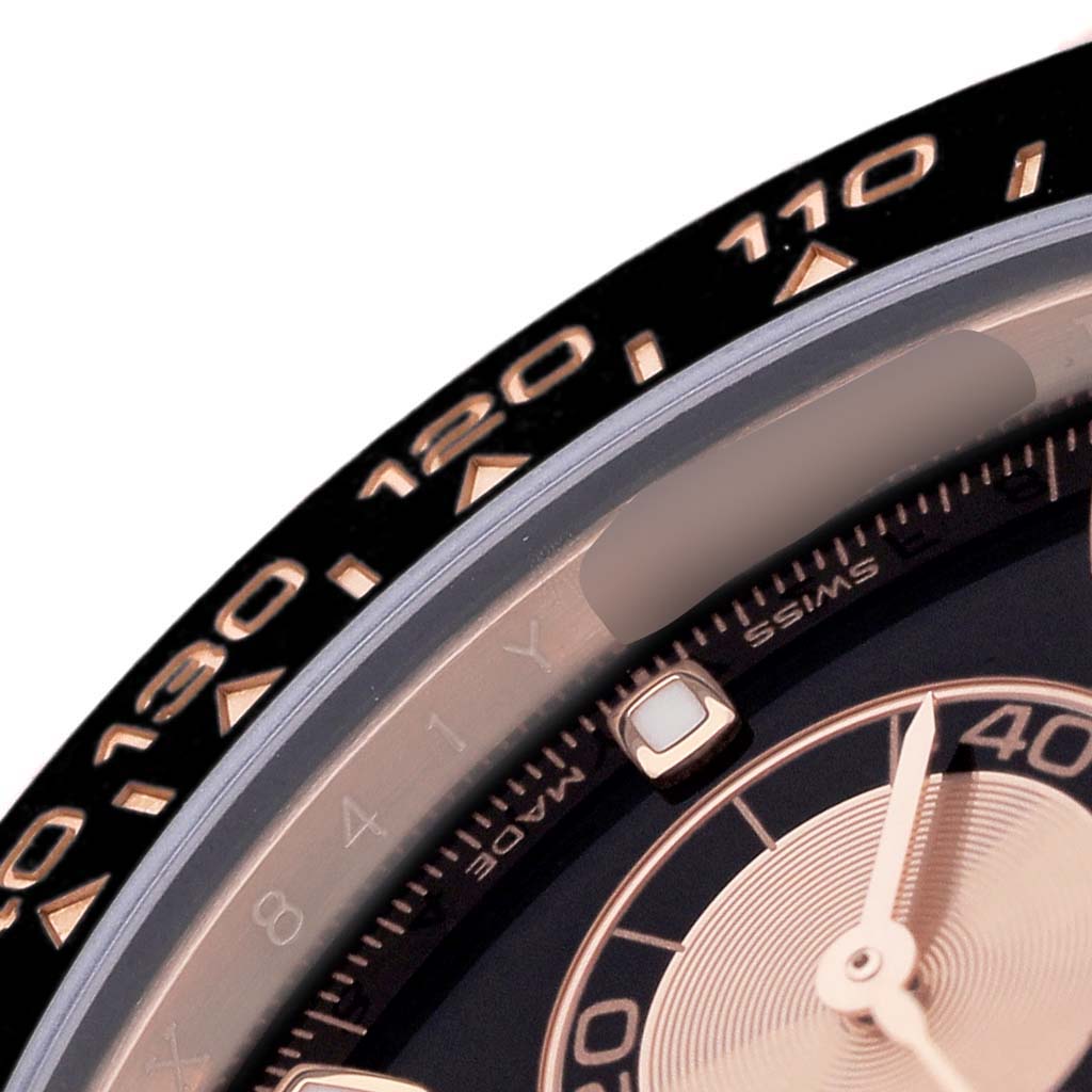 The image shows a close-up of the Rolex Daytona 116515LN Men's Rose Gold Brown Dial's bezel, partial dial, and hand, angled slightly from above.