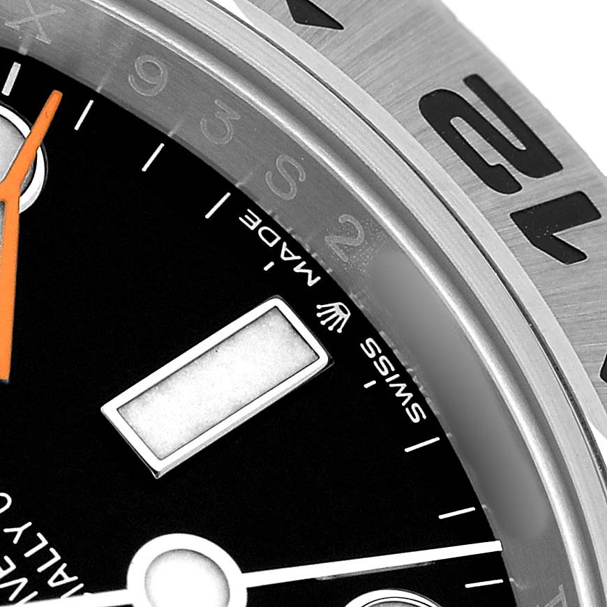 The image shows a close-up of the Rolex Explorer 226570 Men's Stainless Steel Black Dial dial and bezel, featuring the minute markers and part of the orange hand.