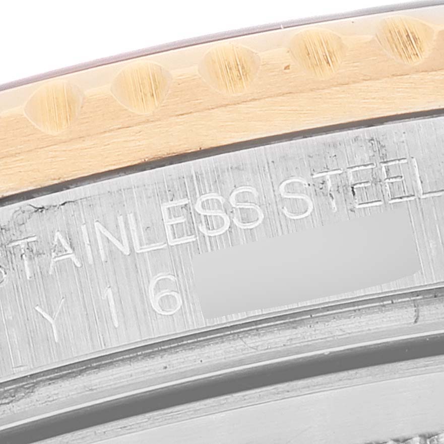 This close-up image shows the side engraving and part of the bezel of a Rolex GMT-Master 16713 Men's Steel and Gold (two tone) Brown Dial 16713 Men's Steel and Gold (two tone) Brown Dial.