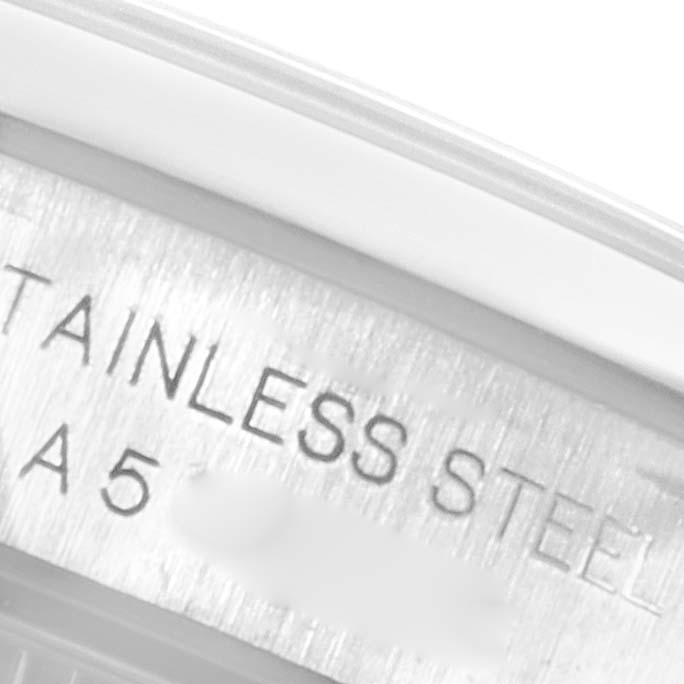 The image shows a close-up of the casing edge of an Oyster Perpetual Rolex watch, highlighting the "STAINLESS STEEL" engraving.