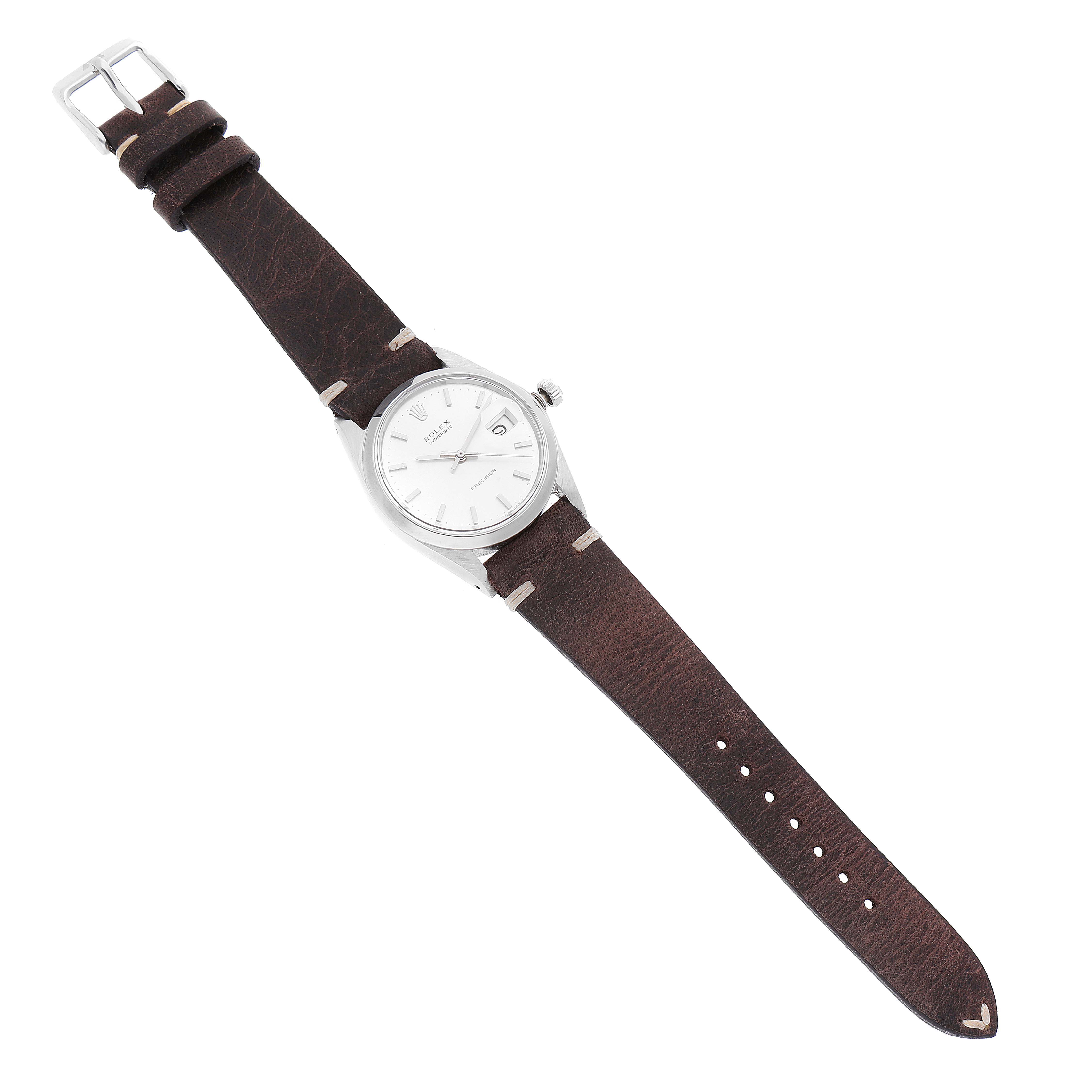 The image shows a Rolex Date 6694 Men's Stainless Steel Silver Dial 6694 Men's Stainless Steel Silver Dial model watch with a brown leather strap, viewed from a top-down angle.