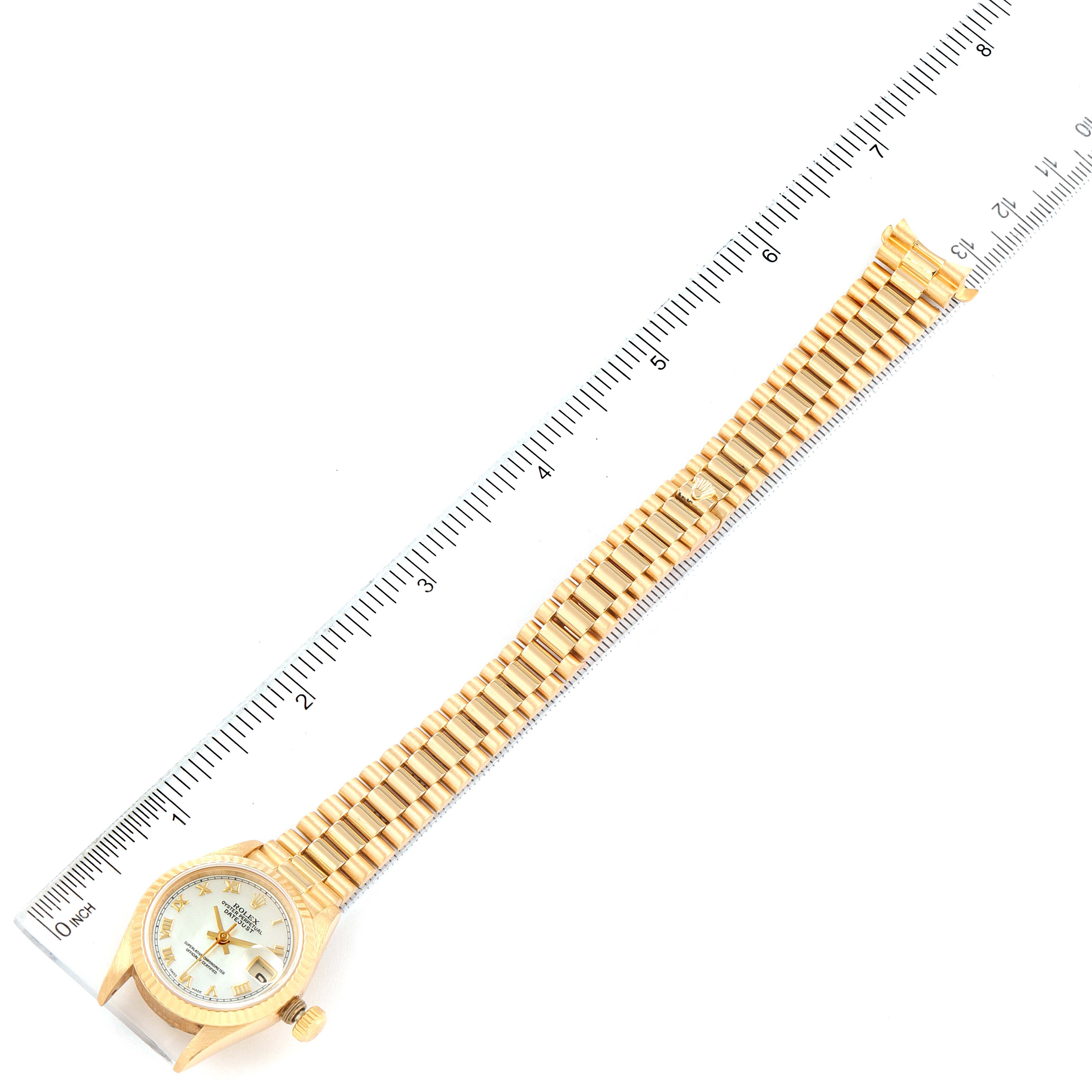 The image shows a top view of a Rolex President 69178 Women's Yellow Gold Mother of Pearl Dial 69178 Women's Yellow Gold Mother of Pearl Dial model watch with a ruler for scale.