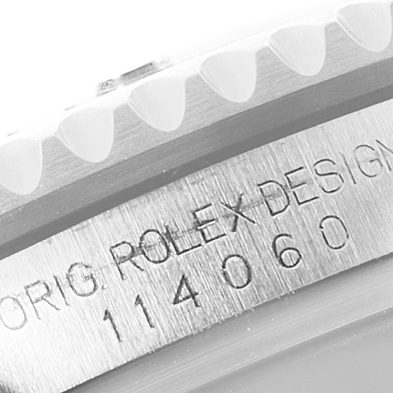 The image displays a close-up of the engraved serial number and text on the bezel of a Rolex Submariner 114060 Men
s Stainless Steel Black Dial 114060 Men
s Stainless Steel Black Dial watch.