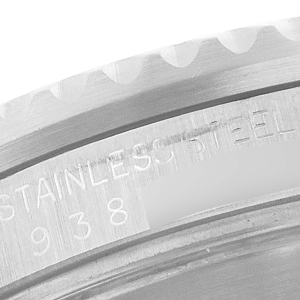 This image shows a close-up of the Rolex Submariner 168000 Men's Stainless Steel Black Dial 168000 Men's Stainless Steel Black Dial's bezel and part of its case, highlighting the engraved "STAINLESS STEEL".