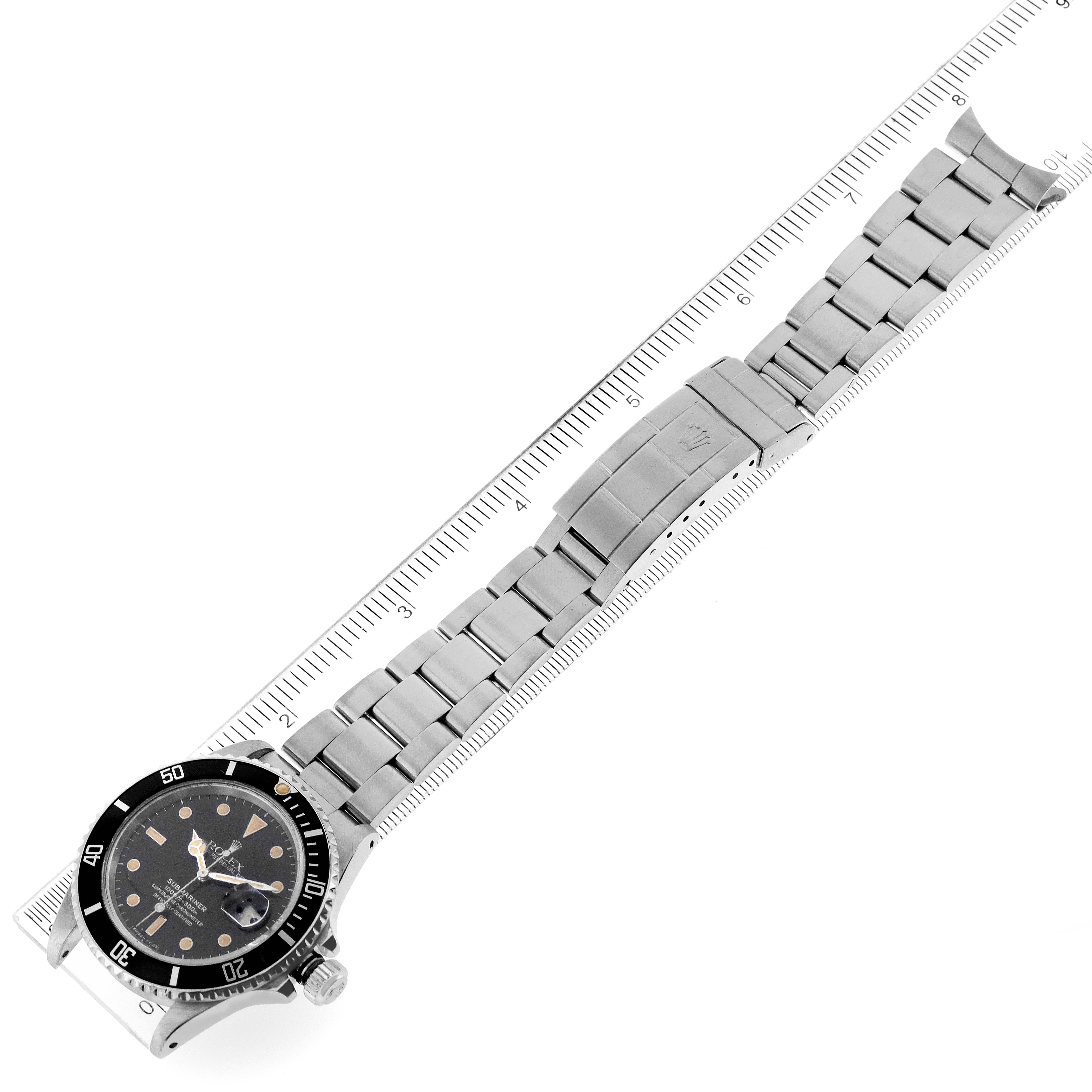 The image shows a top-down view of a Rolex Submariner 168000 Men's Stainless Steel Black Dial 168000 Men's Stainless Steel Black Dial watch, displaying the case, dial, bezel, crown, and bracelet with clasp, alongside a ruler for scale.